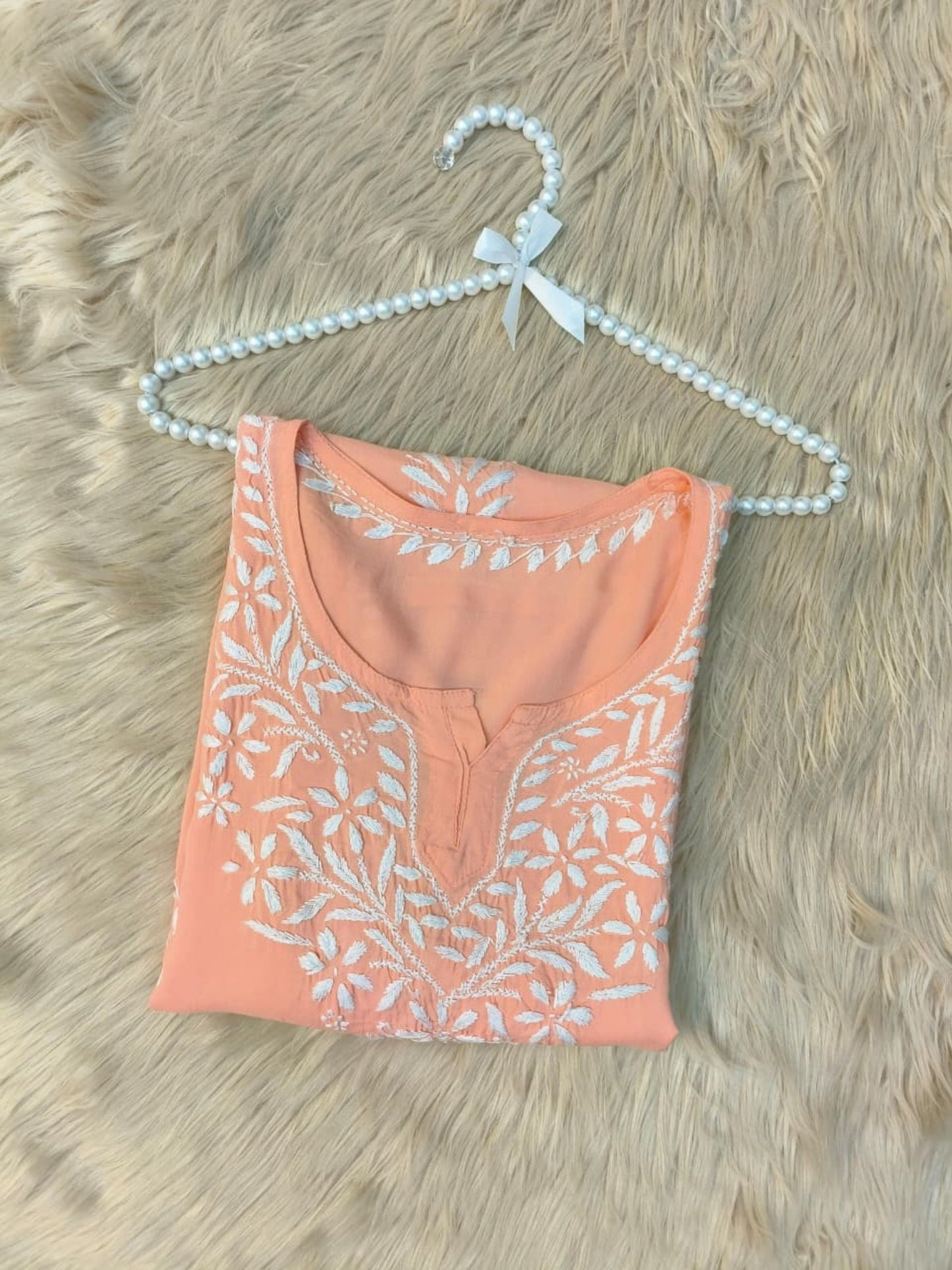 Peach modal short kurta with white hand-embroidered Lucknowi Chikankari design.