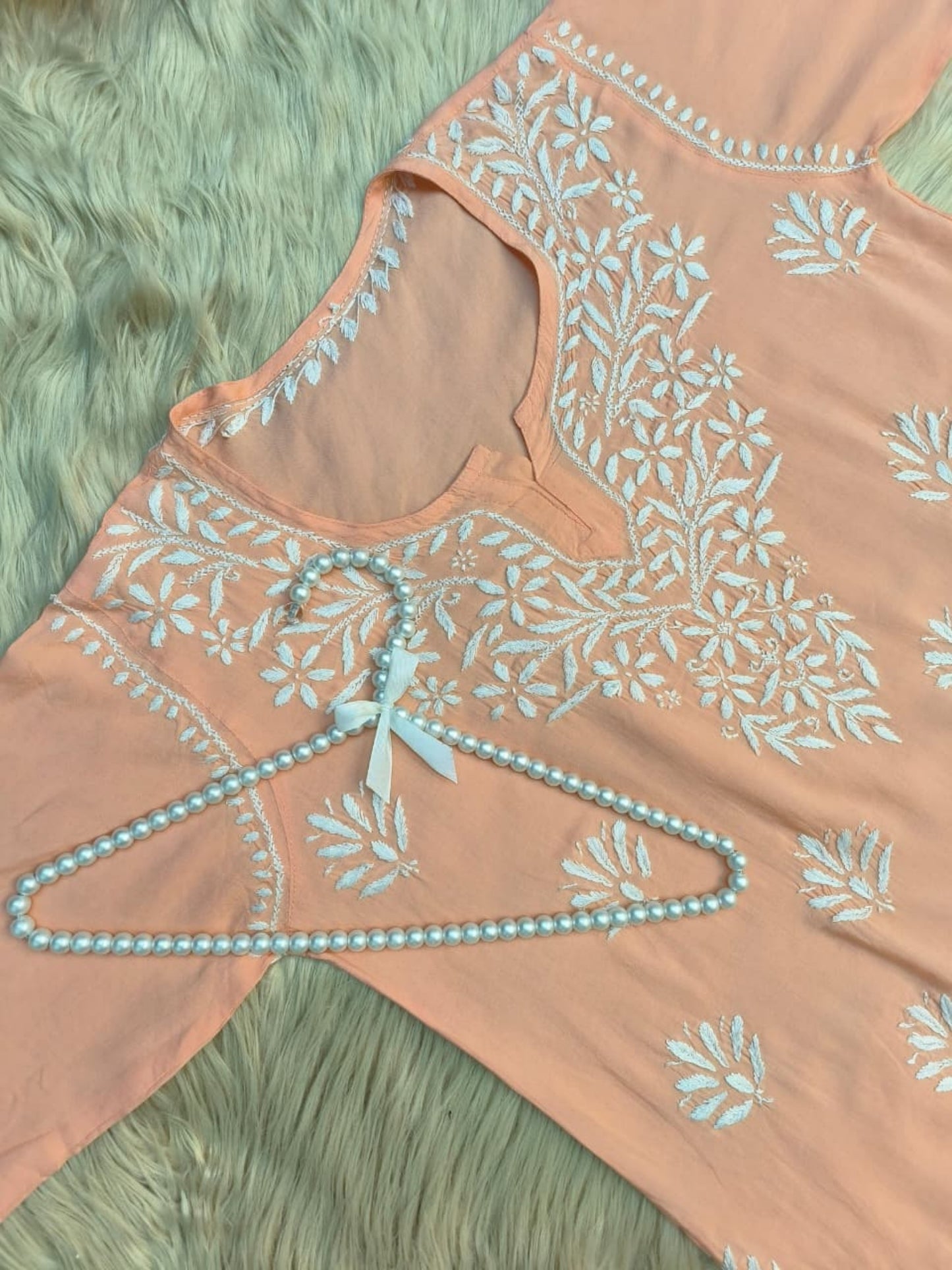Peach modal short kurta with white hand-embroidered Lucknowi Chikankari design.