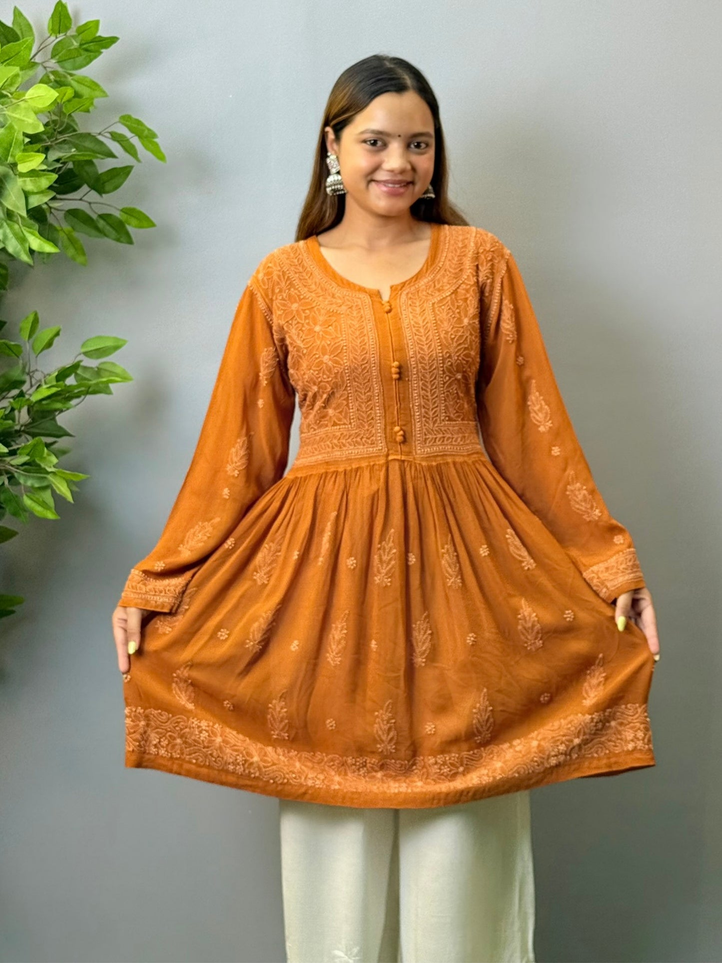 Woman wearing burnt sienna short chikankari angrakha kurta with flared silhouette in viscose fabric