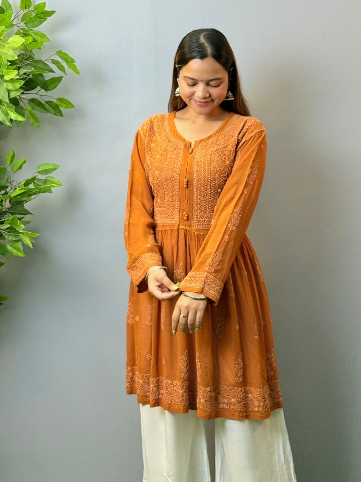 Woman wearing burnt sienna short chikankari angrakha kurta with flared silhouette in viscose fabric