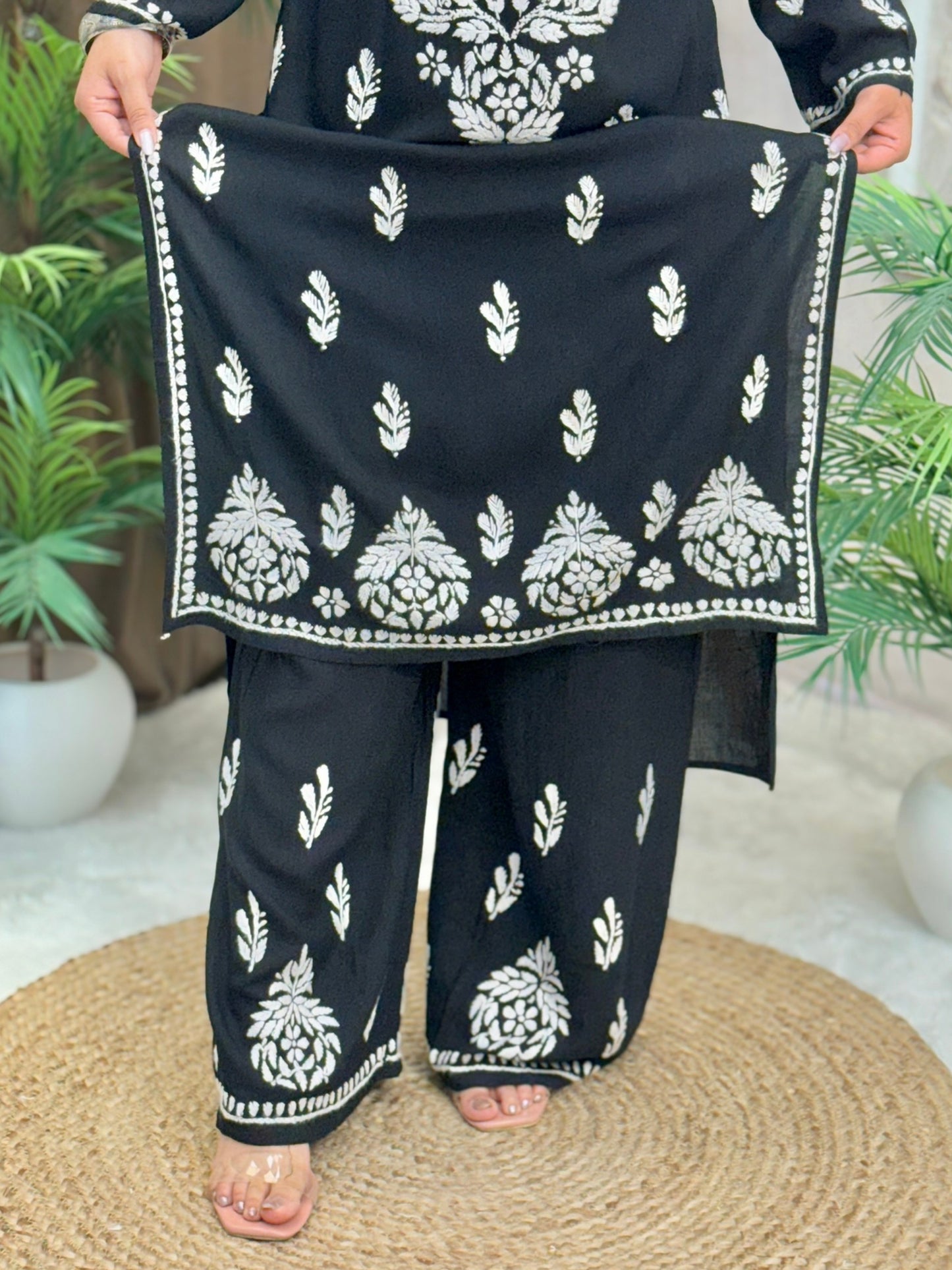 Woman wearing a black rayon chikankari kurta and pant set with white hand embroidery