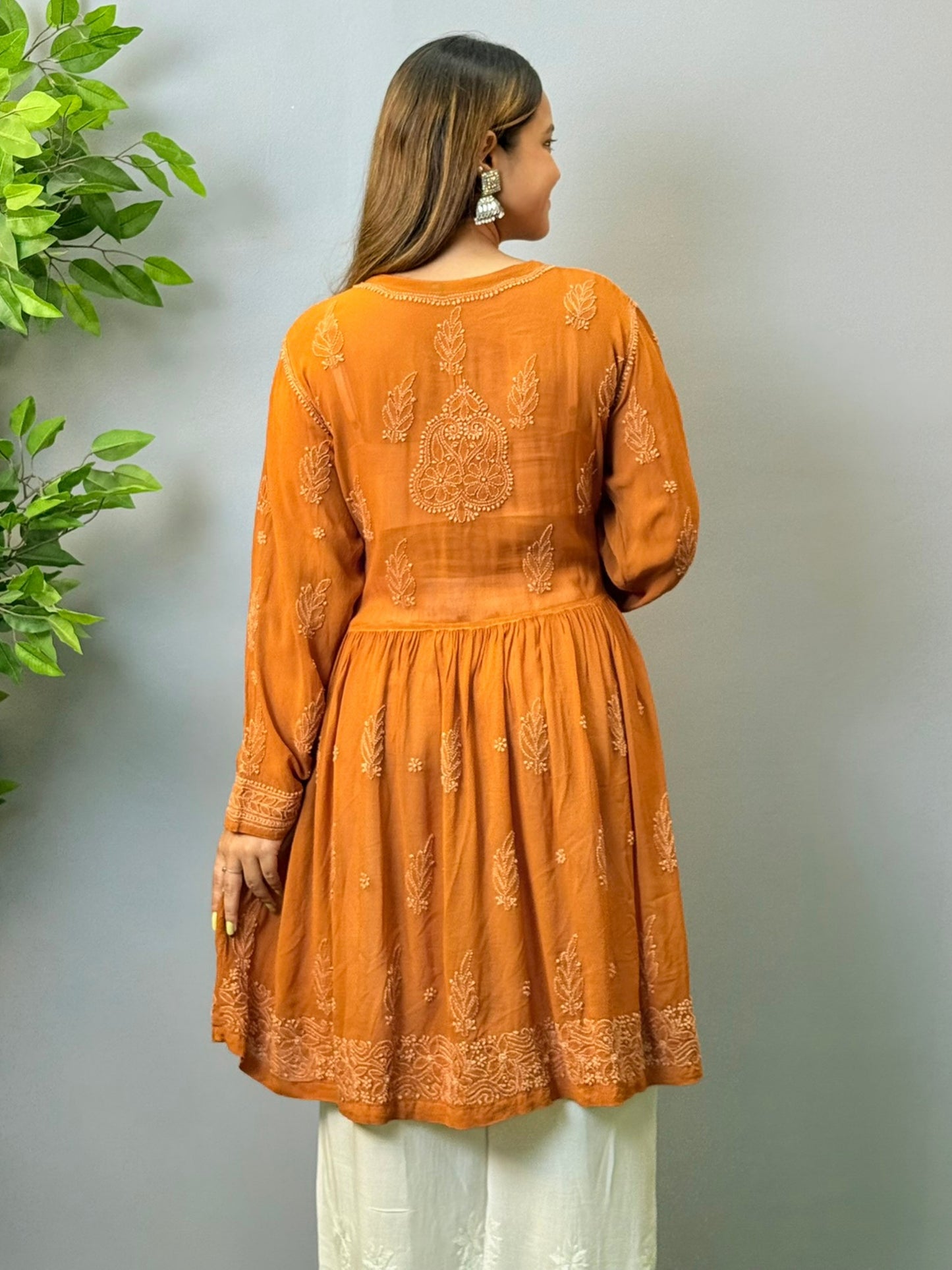 Woman wearing burnt sienna short chikankari angrakha kurta with flared silhouette in viscose fabric