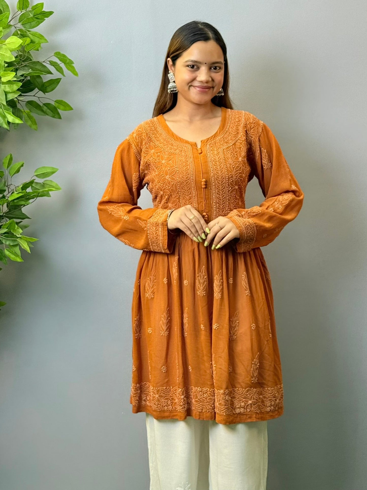 Woman wearing burnt sienna short chikankari angrakha kurta with flared silhouette in viscose fabric
