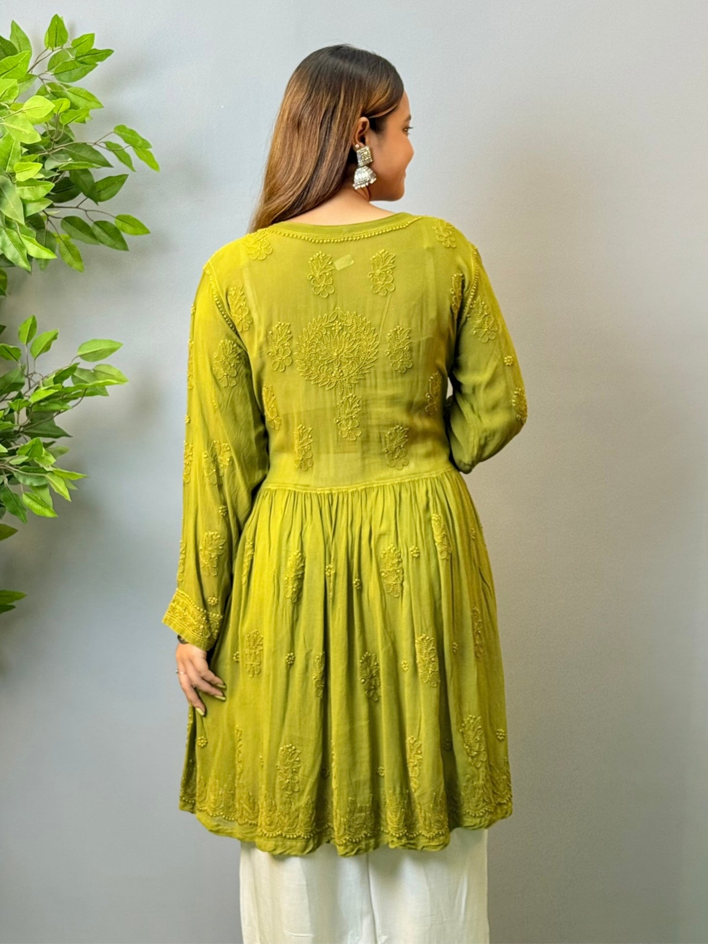 Woman wearing mustard green angrakha-style short chikankari kurta in viscose fabric with flared silhouette