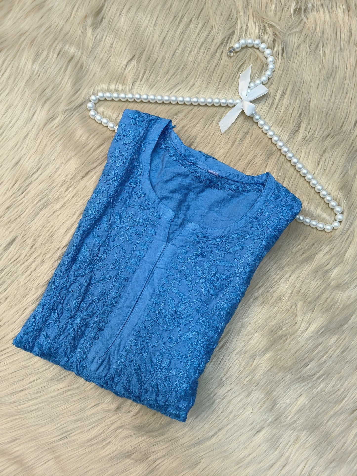 Flat lay of sky blue chanderi chikankari kurta with intricate hand embroidery and lace border