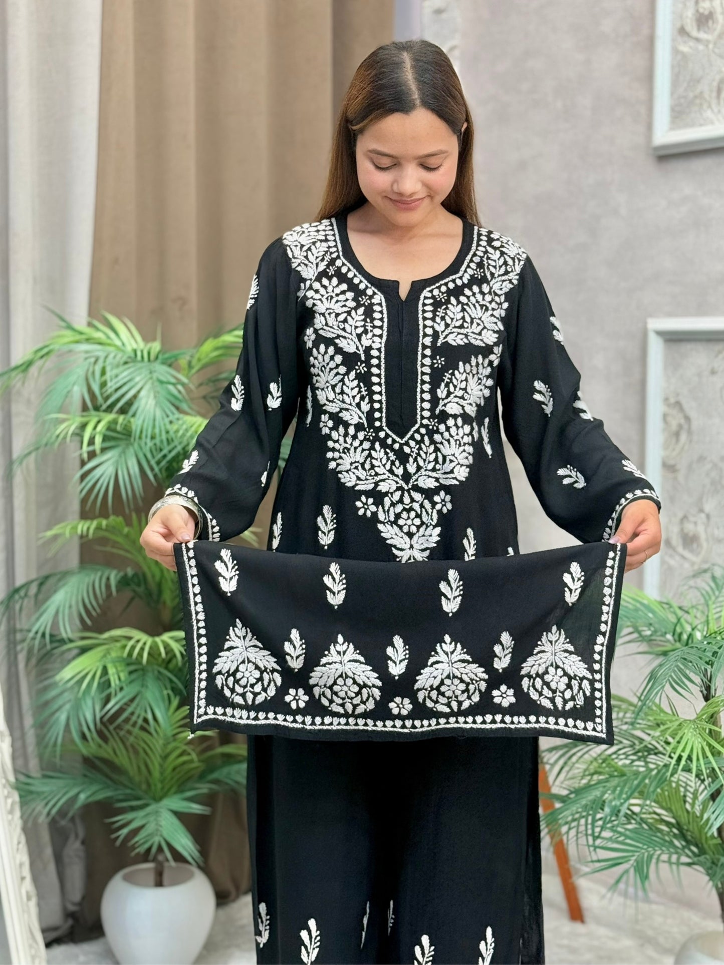 Woman wearing a black rayon chikankari kurta and pant set with white hand embroidery