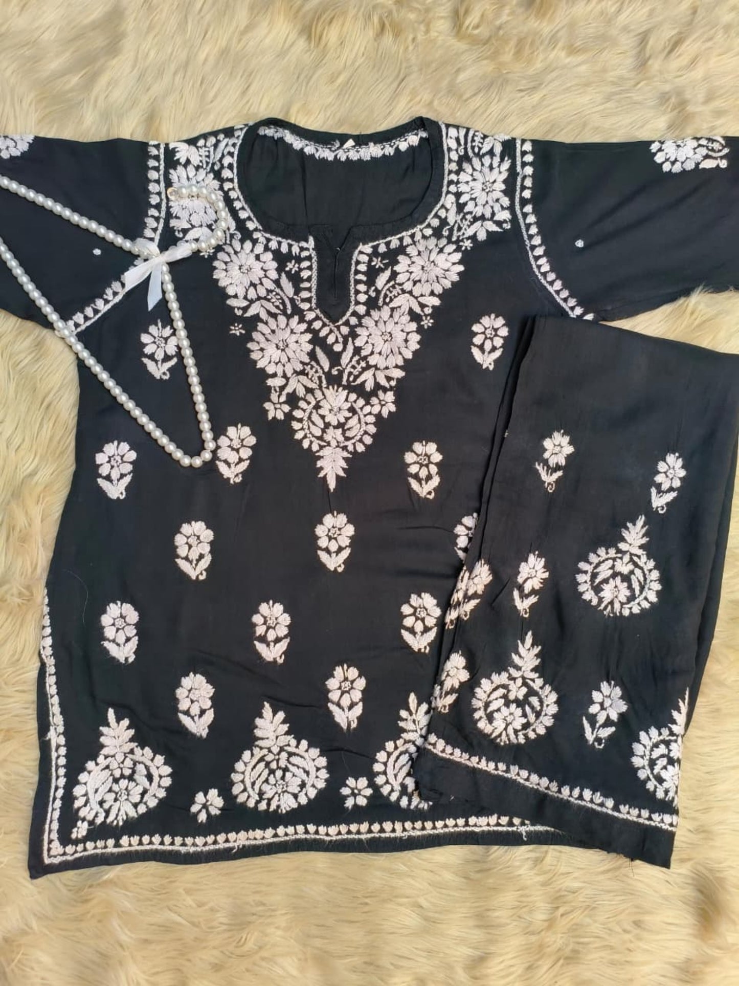 Black rayon Lucknow Chikankari kurta and palazzo set with intricate white hand embroidery.