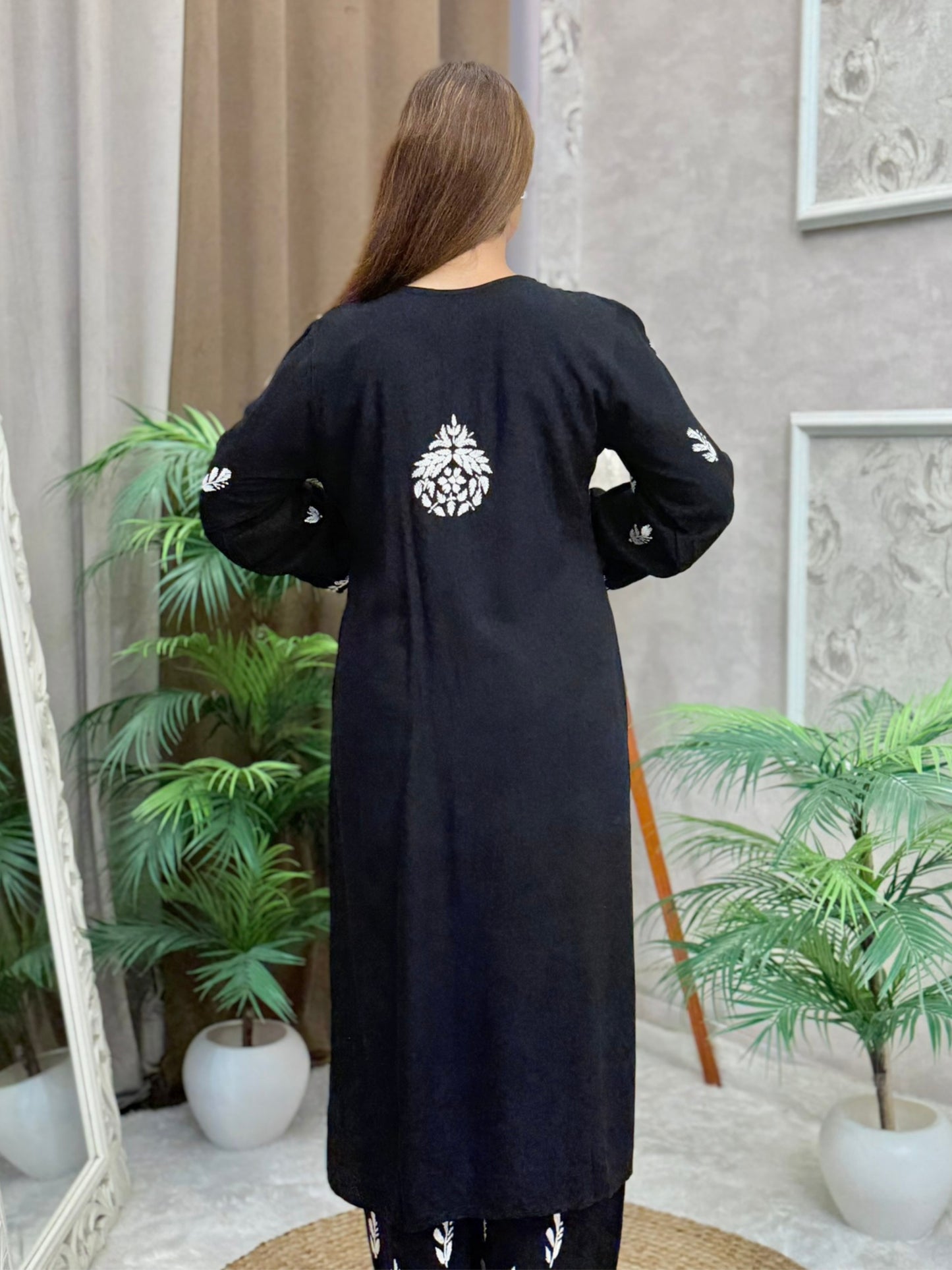 Woman wearing a black rayon chikankari kurta and pant set with white hand embroidery