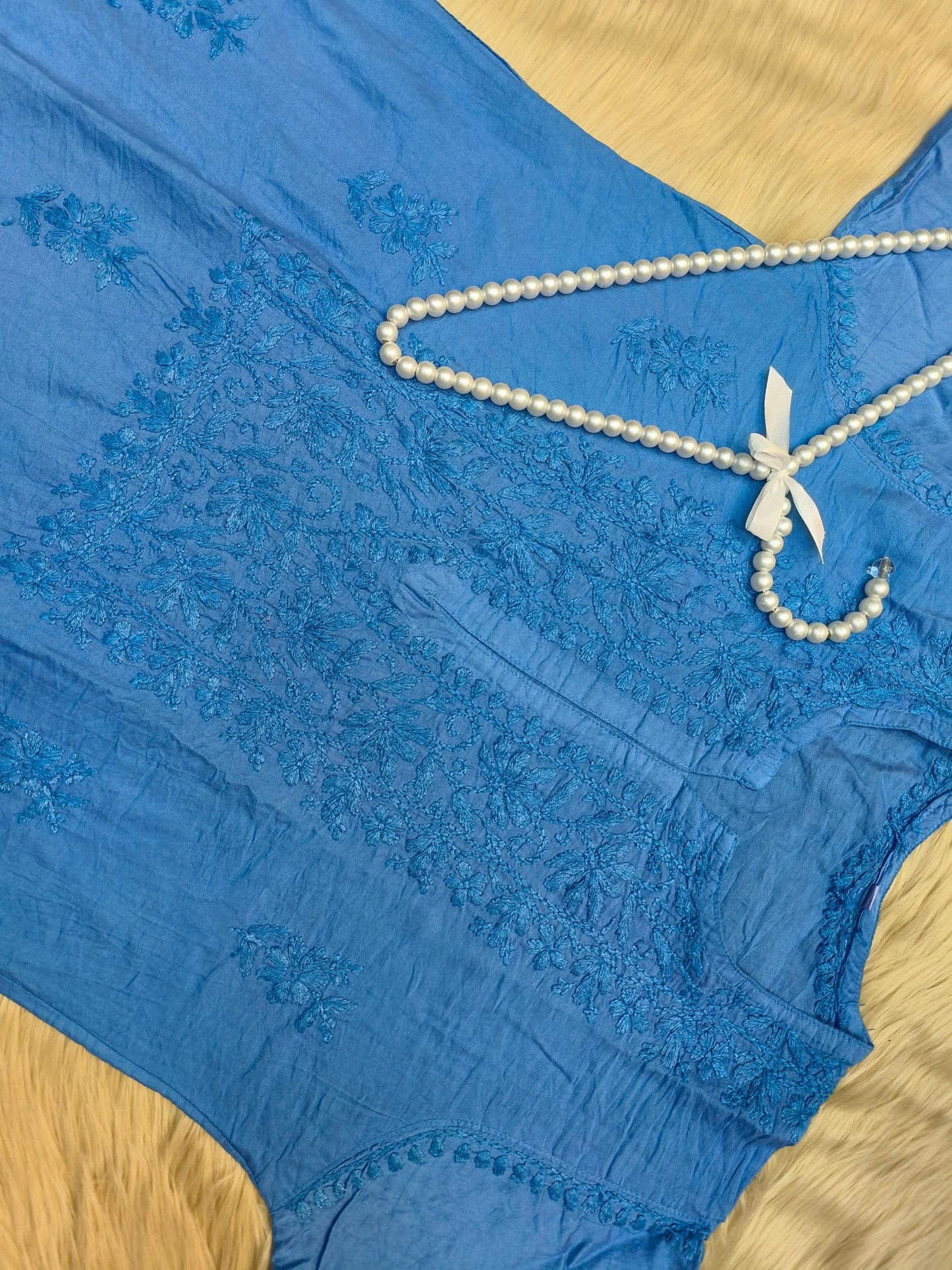 Flat lay of sky blue chanderi chikankari kurta with intricate hand embroidery and lace border