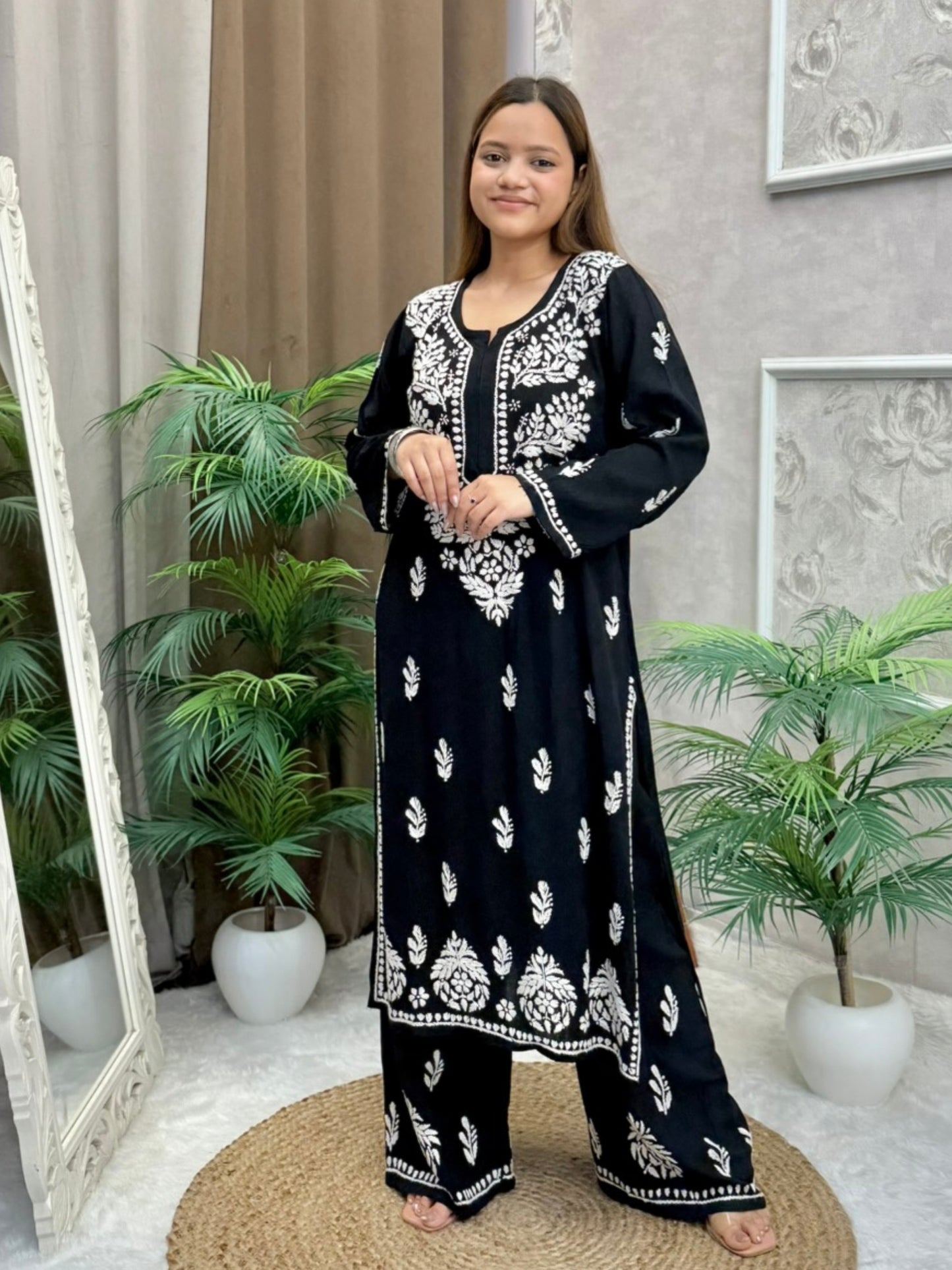 Woman wearing a black rayon chikankari kurta and pant set with white hand embroidery