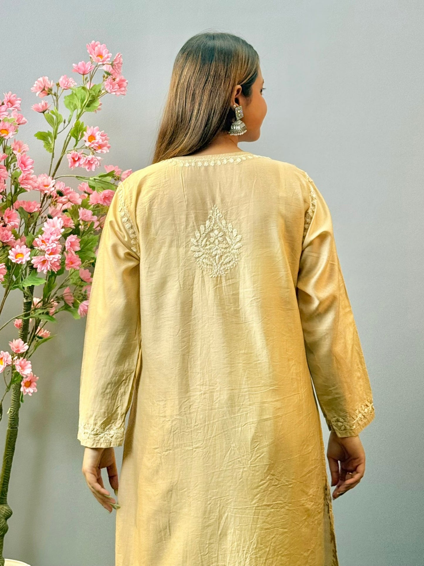 Woman wearing beige golden Chikankari kurta and palazzo set with elegant hand embroidery in chanderi fabric