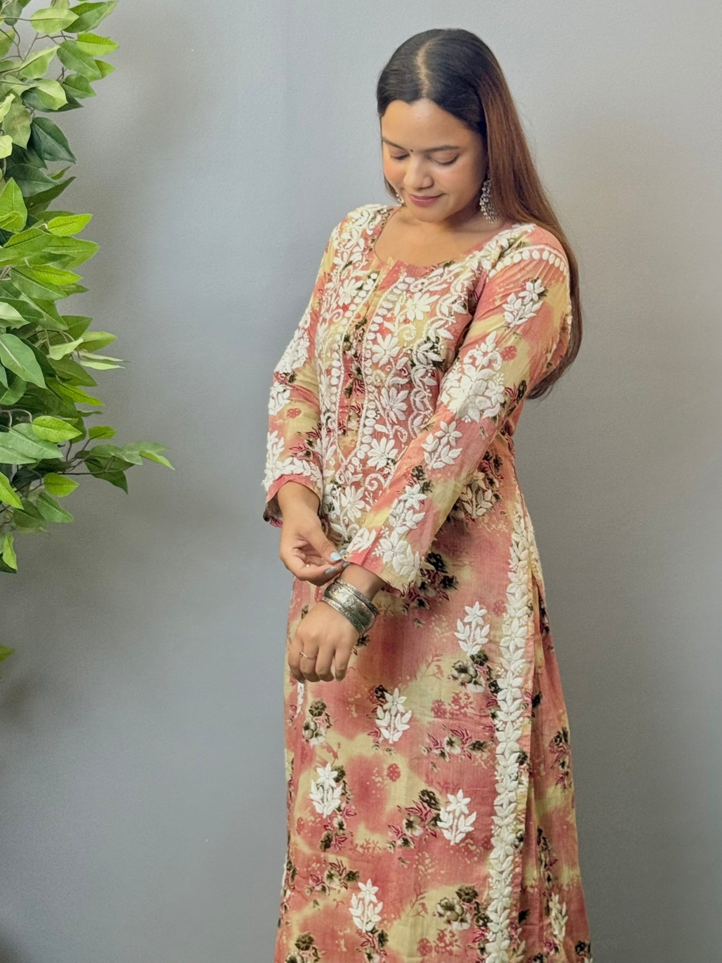 Model wearing a blush peach floral printed chikankari kurta and palazzo set in soft mulmul fabric.