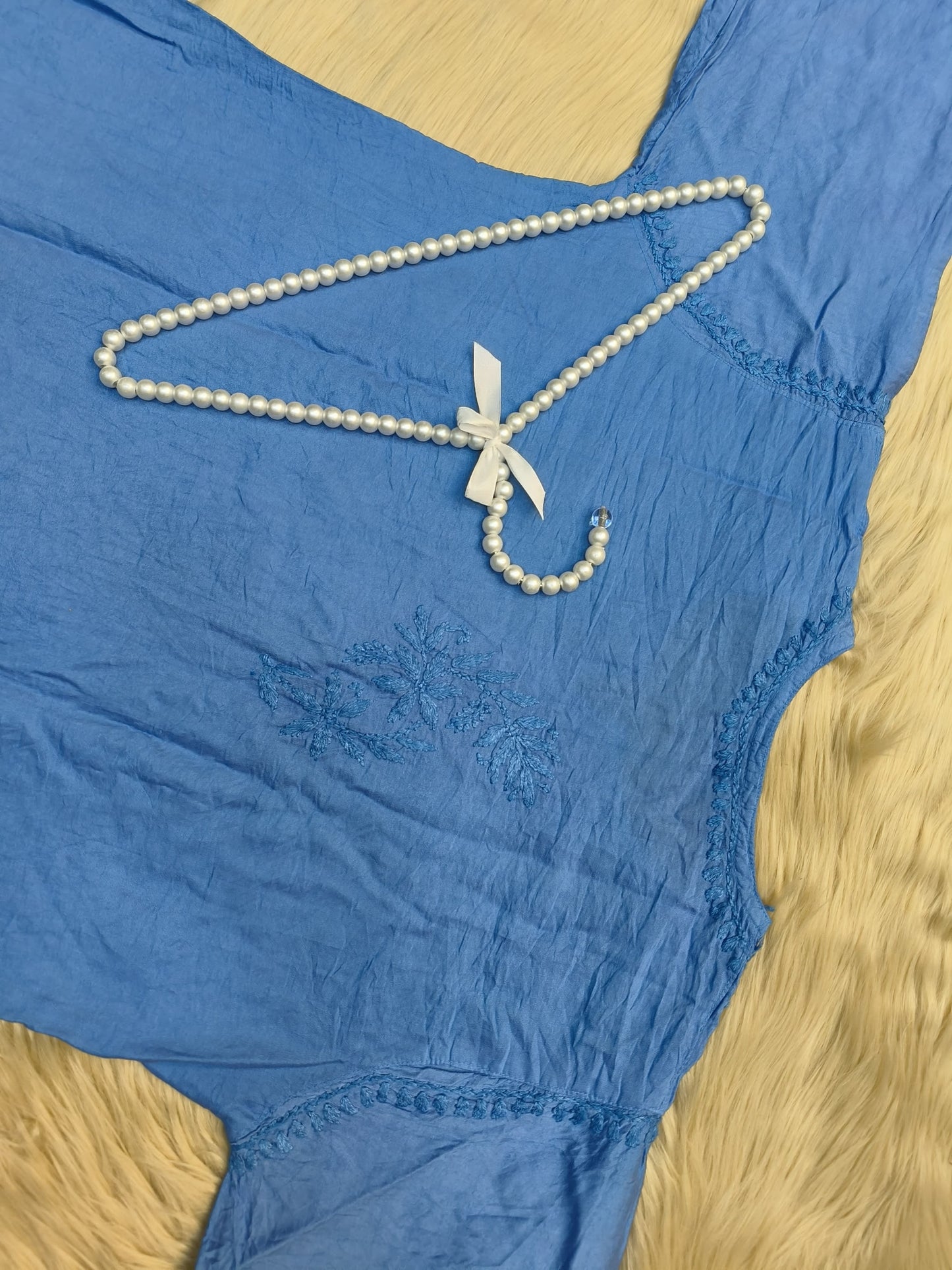 Flat lay of sky blue chanderi chikankari kurta with intricate hand embroidery and lace border