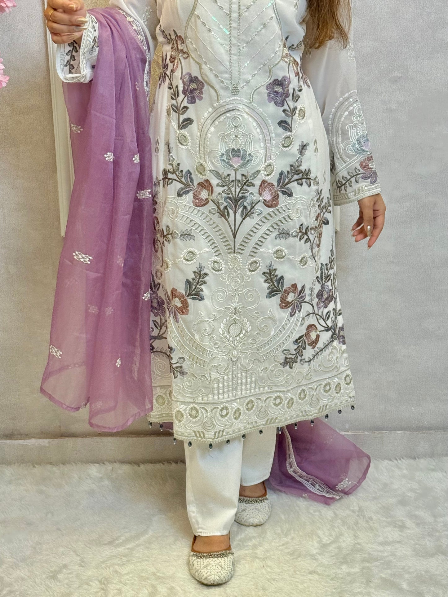 Model wearing a white embroidered georgette kurta with lycra stretchable pants and lavender embroidered georgette dupatta – Designer Wear Collection.