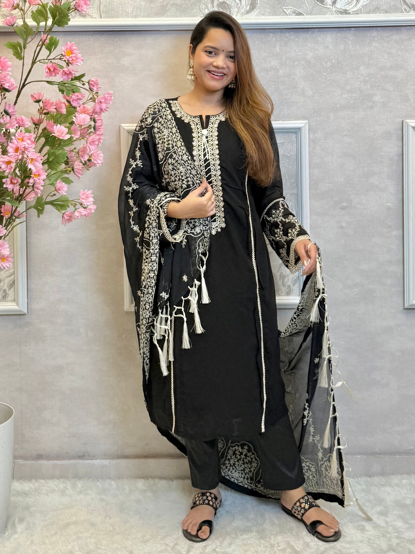 Model wearing a black georgette kurta with lycra stretchable pants and embroidered georgette dupatta with tassels – Designer Wear Collection.