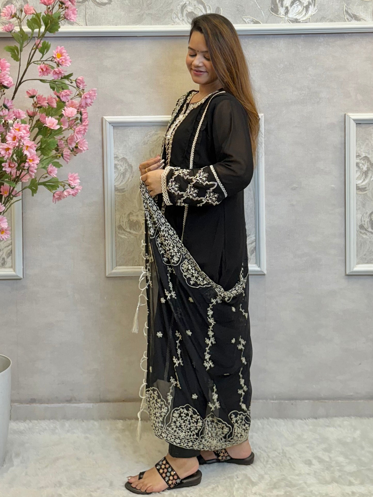 Model wearing a black georgette kurta with lycra stretchable pants and embroidered georgette dupatta with tassels – Designer Wear Collection.