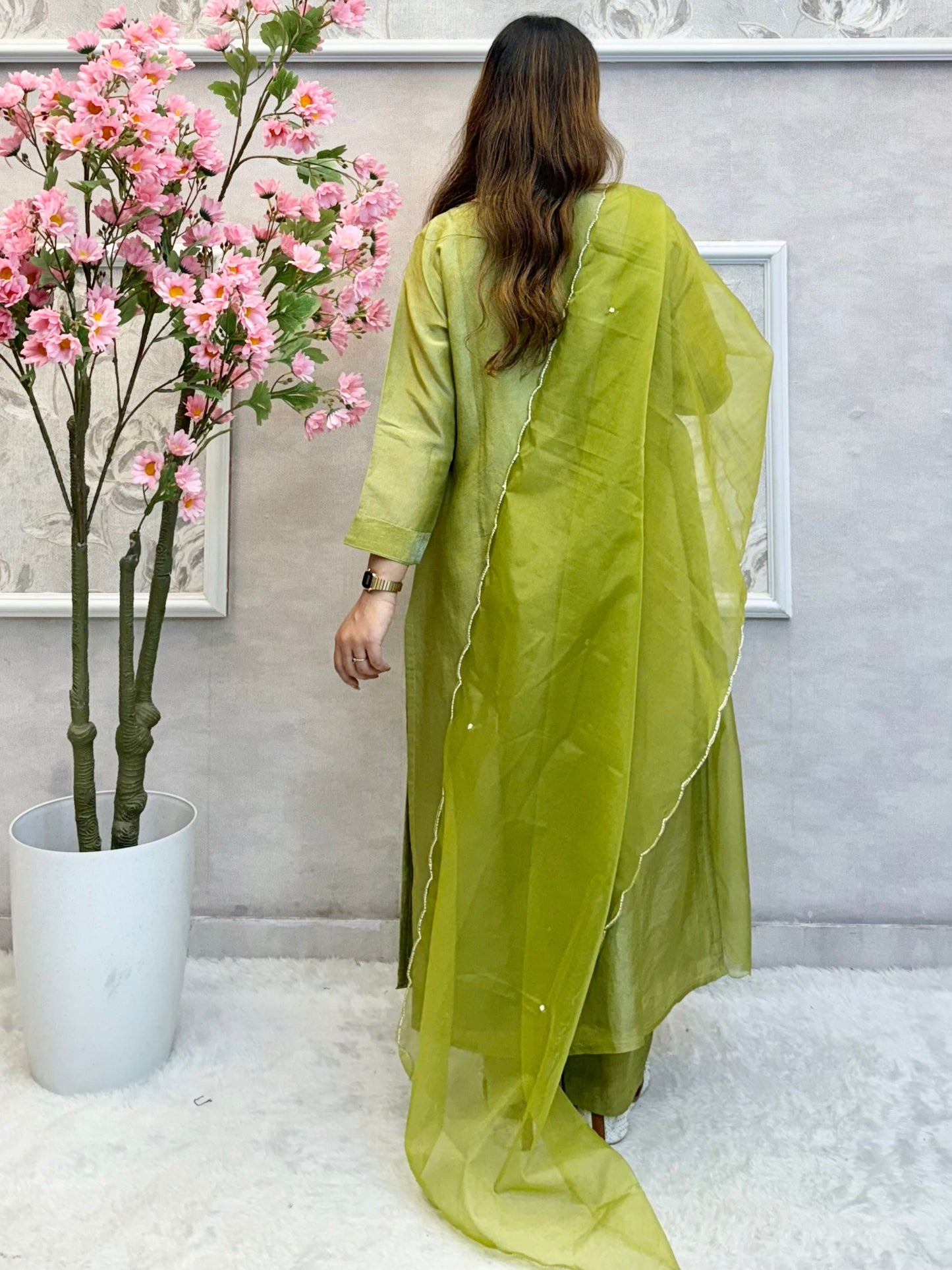 Model wearing an olive green tissue silk kurta with hand embroidery, paired with tissue silk pants and an organza dupatta – Designer Wear Collection.