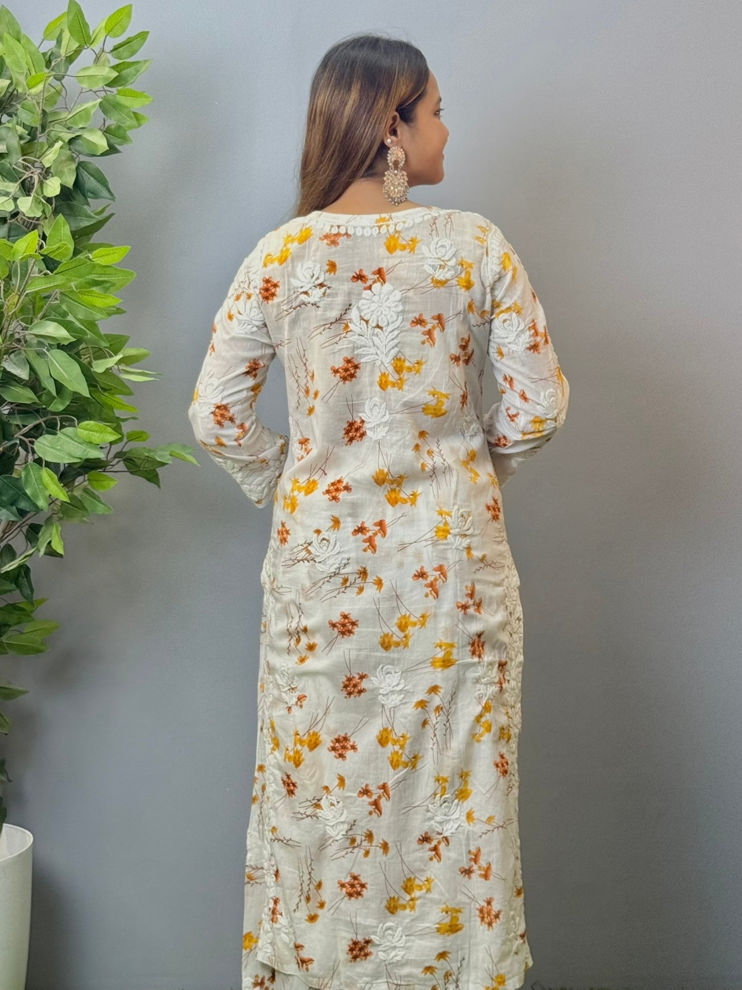 Model wearing ivory mulmul kurta and palazzo set with floral print and 3D hand embroidery.