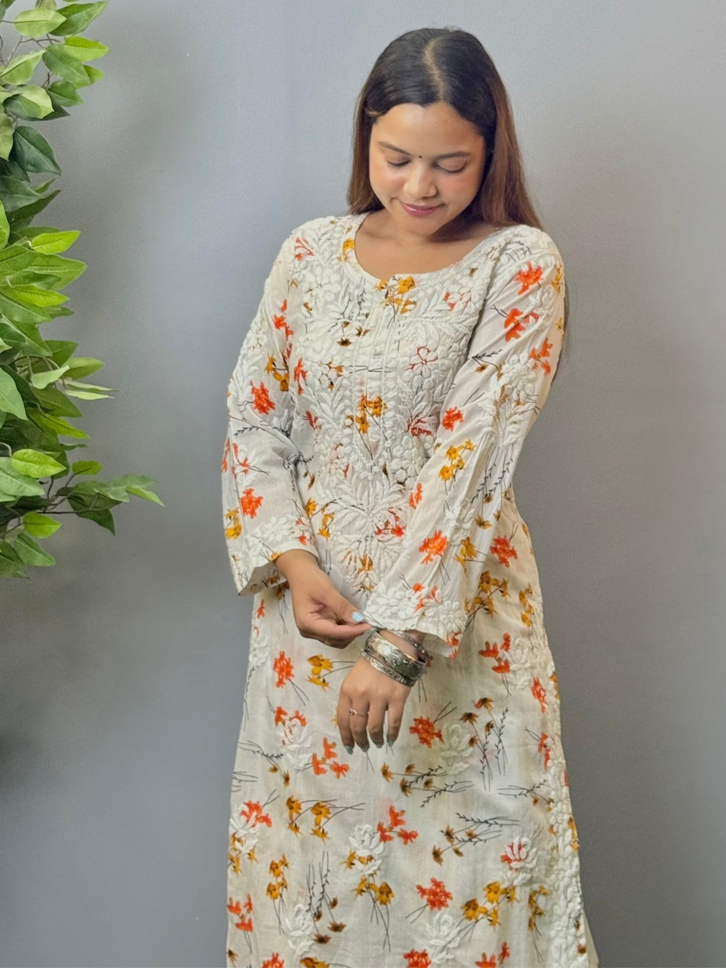 Model wearing ivory floral printed mulmul chikankari kurta and palazzo set with detailed 3D embroidery.