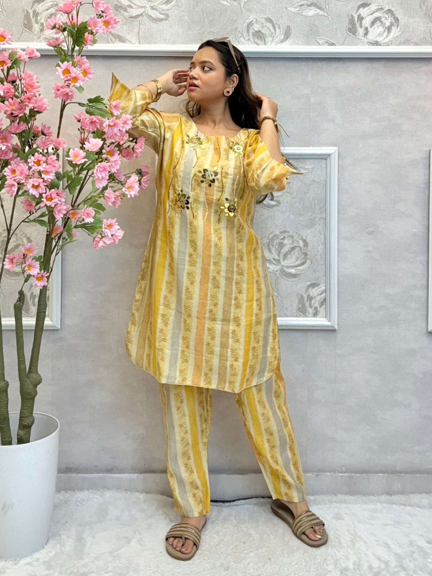 Yellow muslin printed co-ord set with floral embellishments and striped kurta and pants