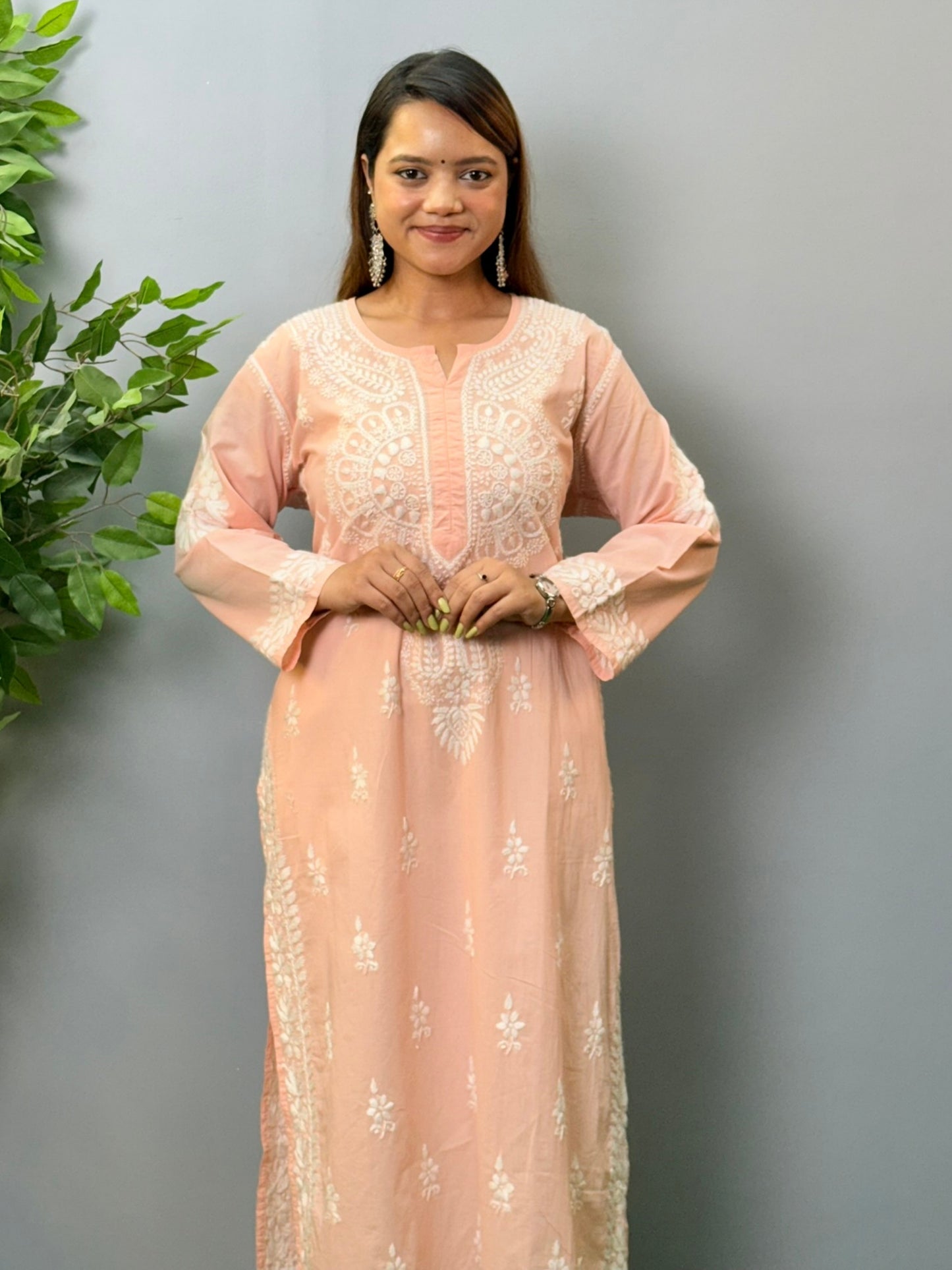 Model wearing a peach pink cotton chikankari kurta with delicate white hand embroidery