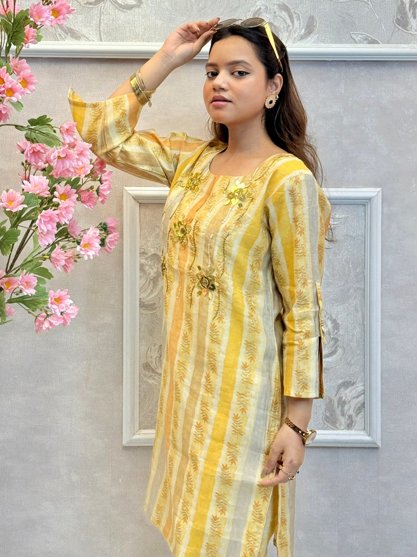 Yellow muslin printed co-ord set with floral embellishments and striped kurta and pants