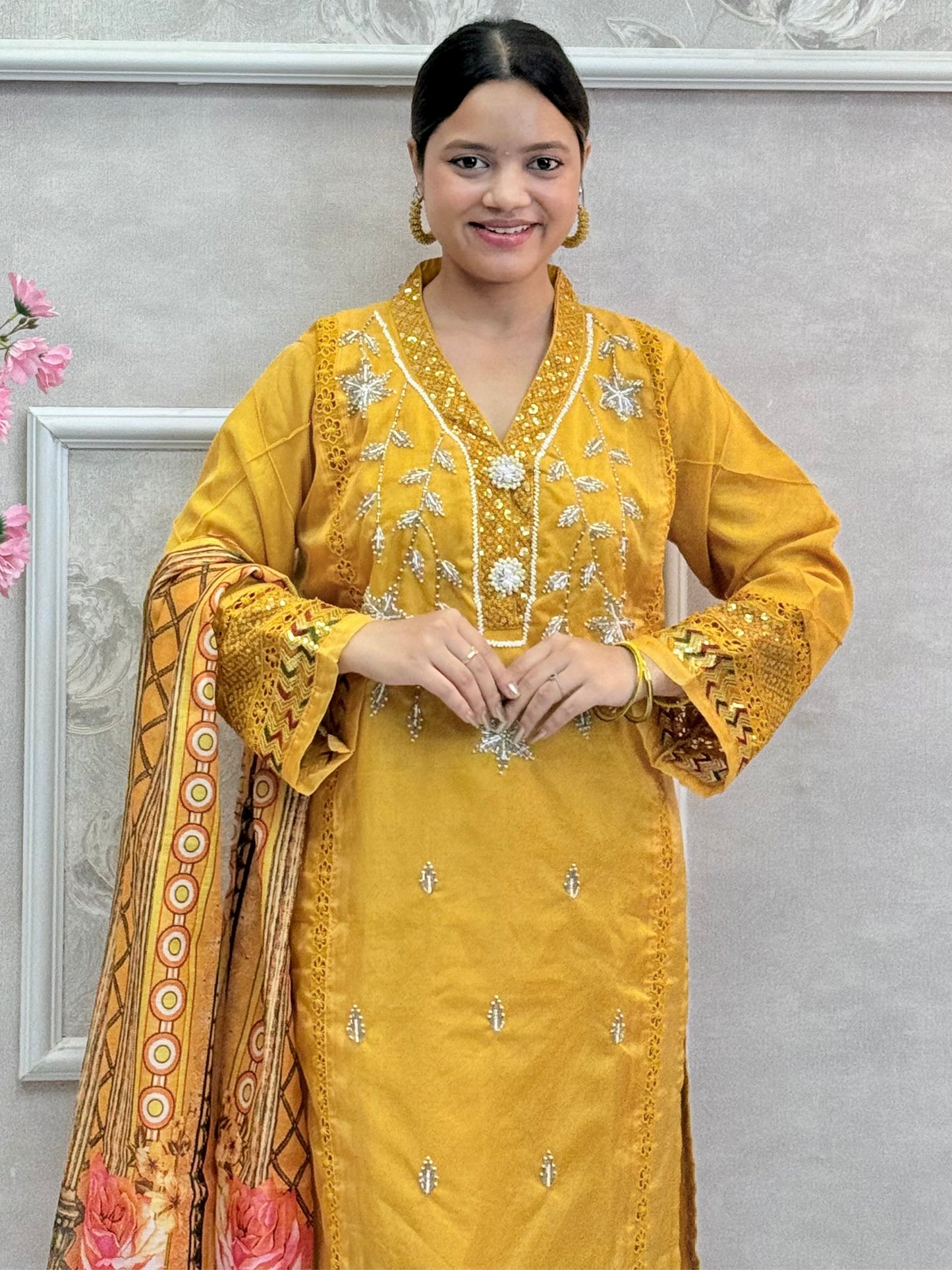 Model wearing a mustard yellow organza kurta with hand embroidery, paired with chanderi pants and a multicolor printed cotton dupatta – Designer Wear Collection.
