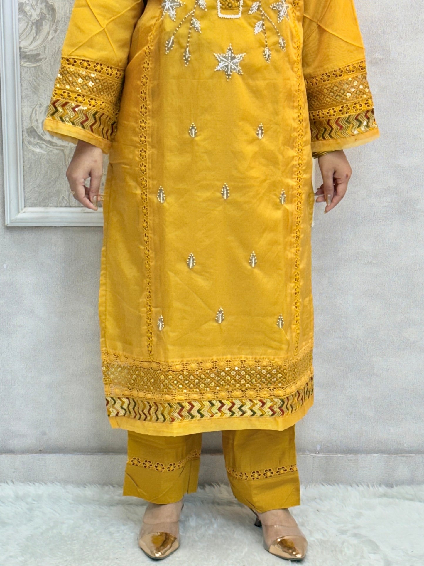 Model wearing a mustard yellow organza kurta with hand embroidery, paired with chanderi pants and a multicolor printed cotton dupatta – Designer Wear Collection.