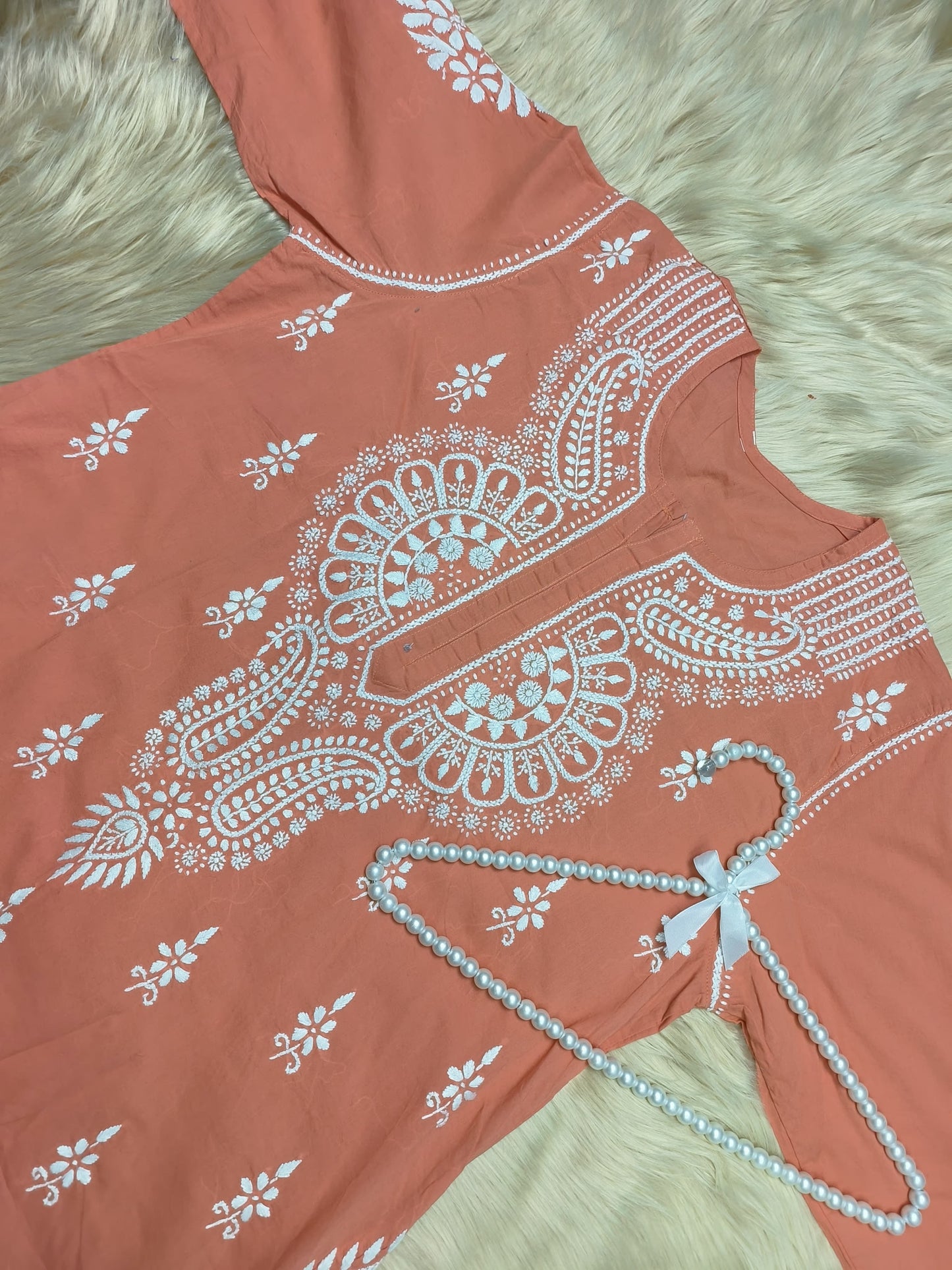 Rust cotton Lucknow Chikankari kurta with white embroidery and pearl hanger on fur background
