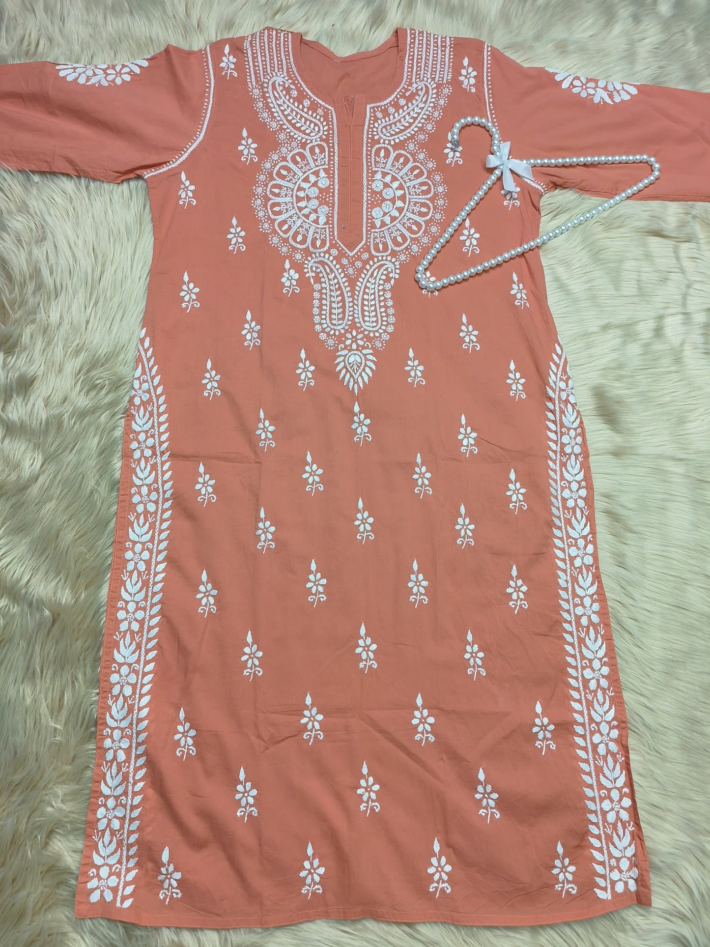 Rust cotton Lucknow Chikankari kurta with white embroidery and pearl hanger on fur background