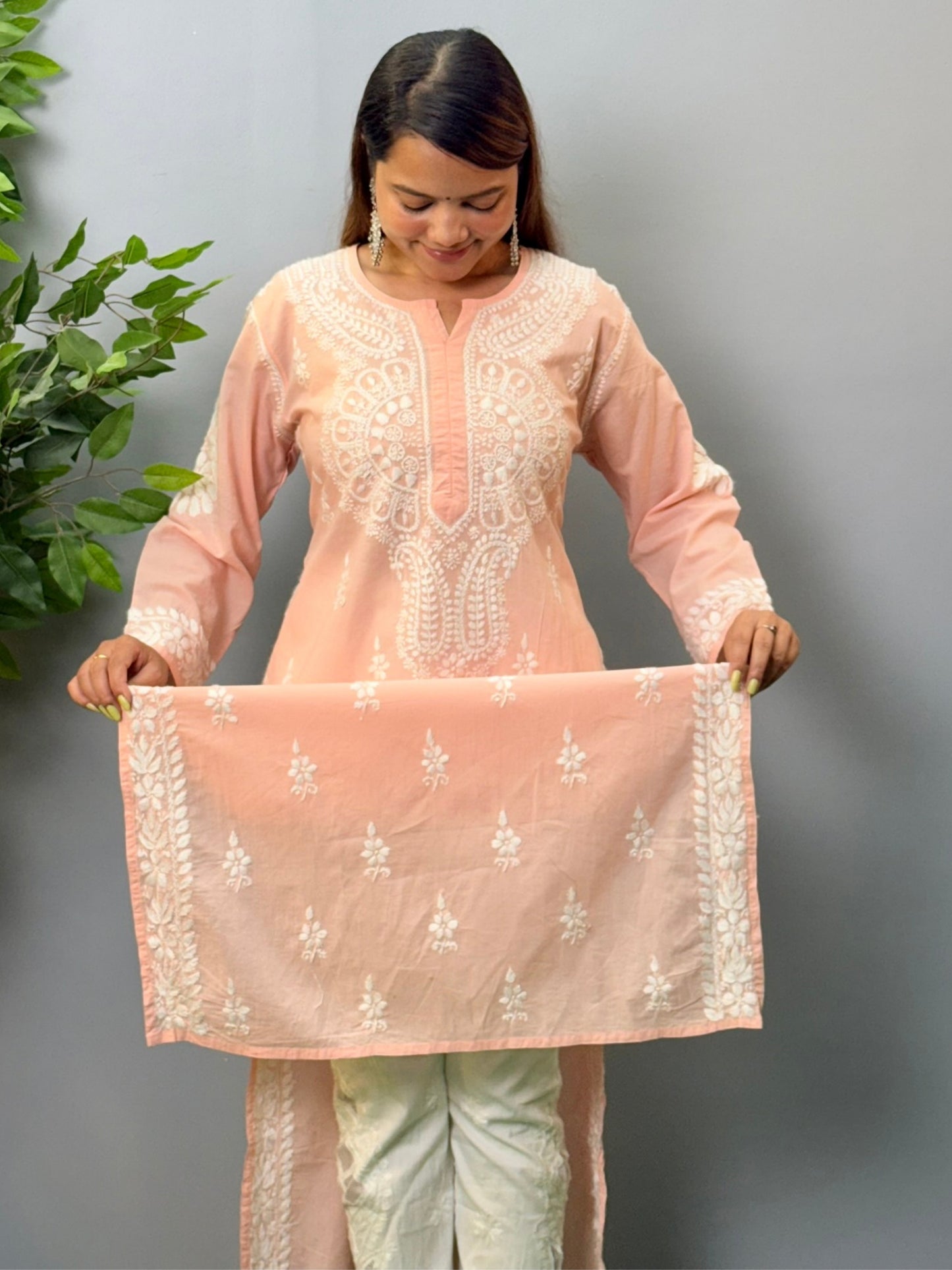 Model wearing a peach pink cotton chikankari kurta with delicate white hand embroidery