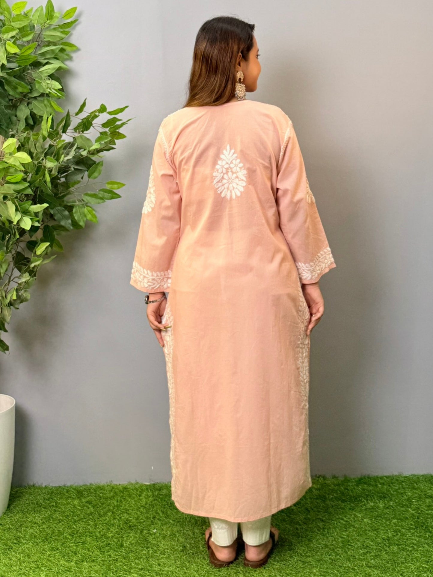 Model wearing a peach pink cotton chikankari kurta with delicate white hand embroidery