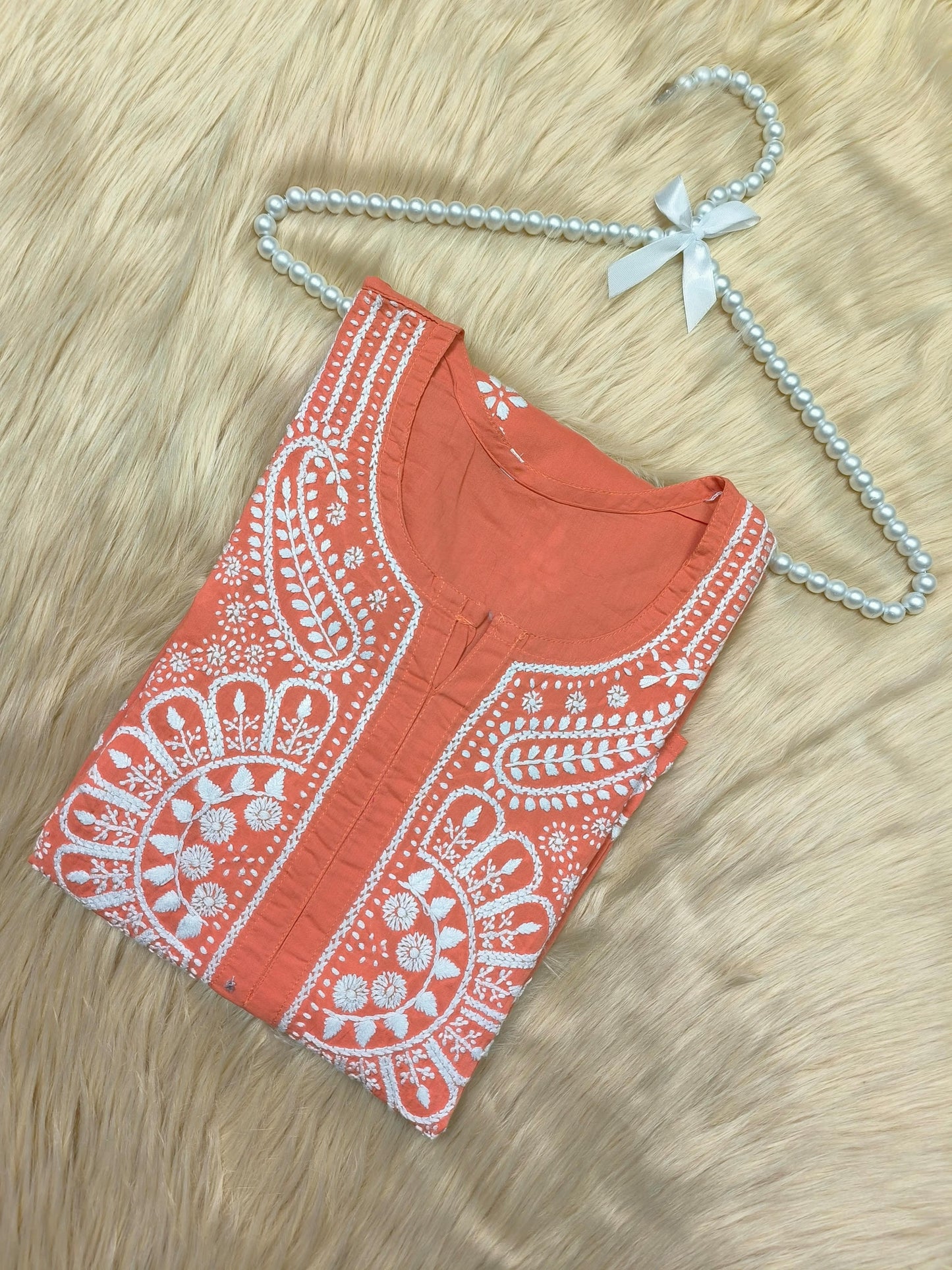 Rust cotton Lucknow Chikankari kurta with white embroidery and pearl hanger on fur background