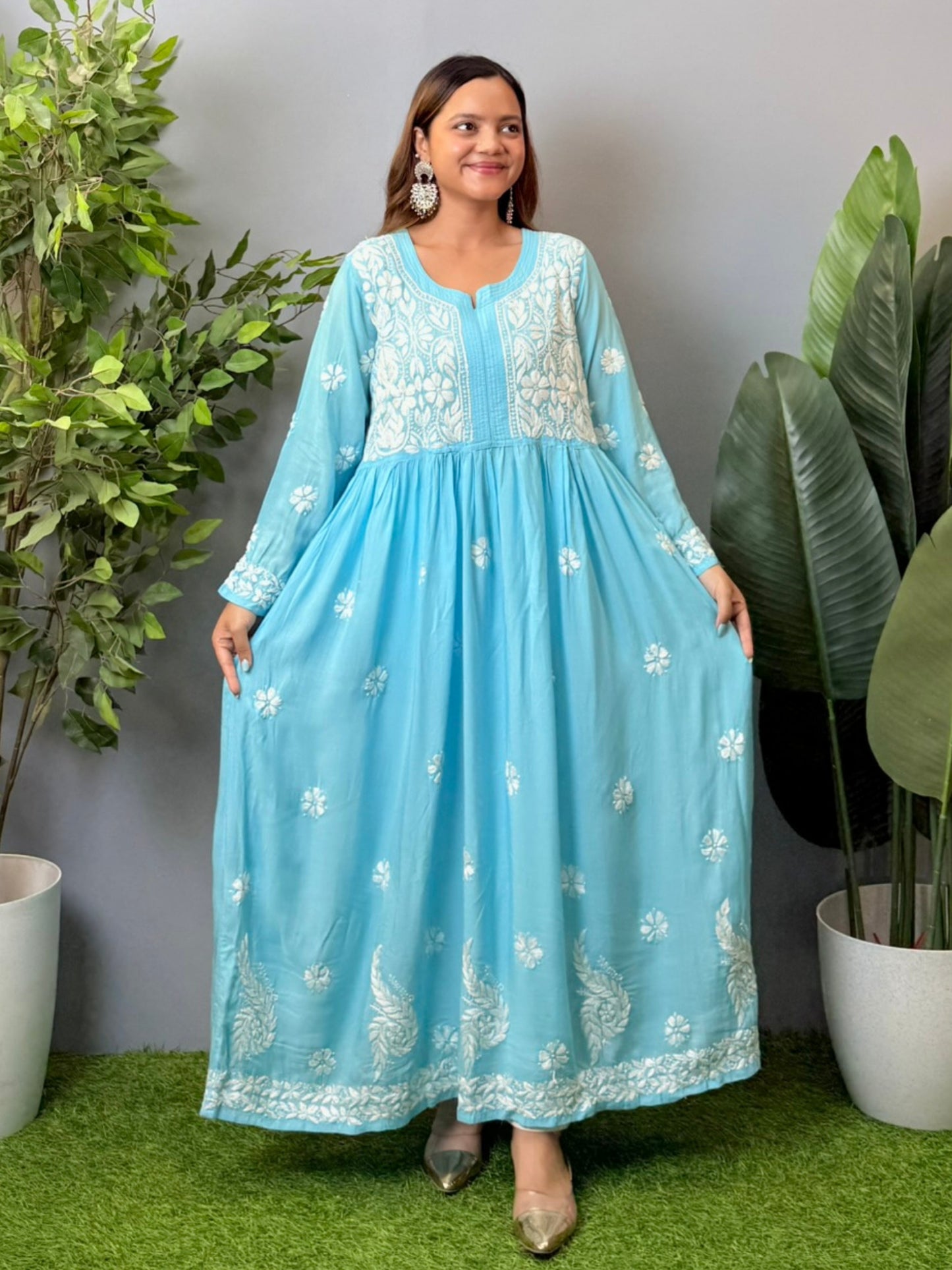 Model wearing a sky blue modal chikankari long frock with white hand embroidery and elegant flared silhouette.
