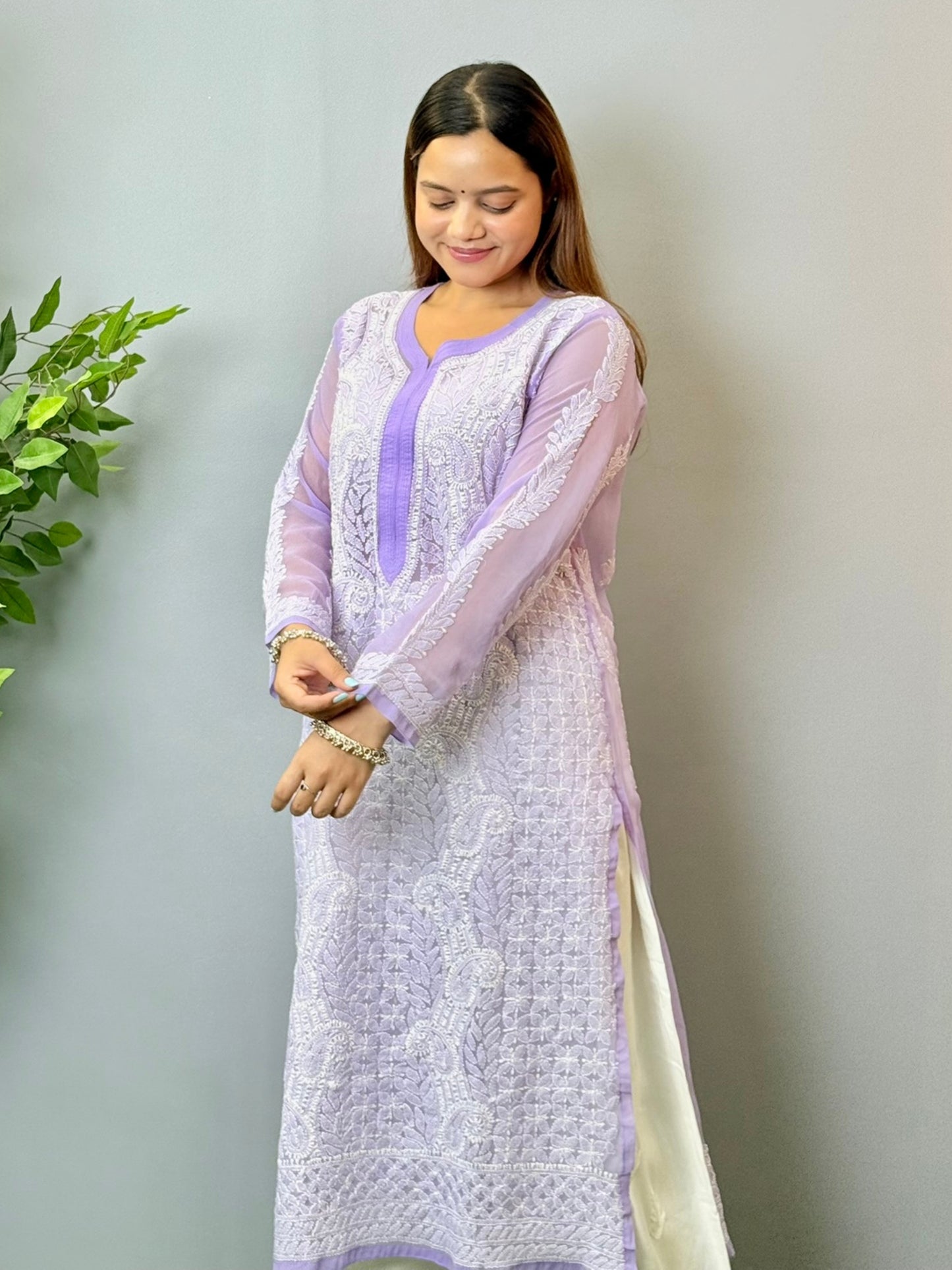 Model wearing a lavender translucent georgette Lucknowi chikankari kurta with heavy hand embroidery, styled with white palazzos for a festive look.