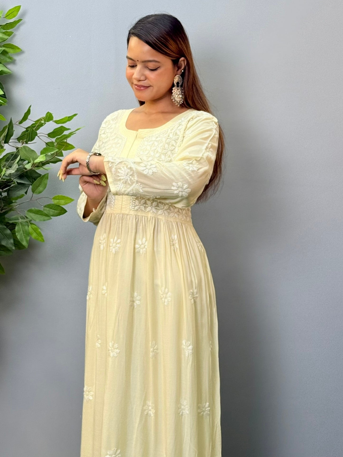 Model wearing an ivory long frock-style modal chikankari kurta with detailed embroidery