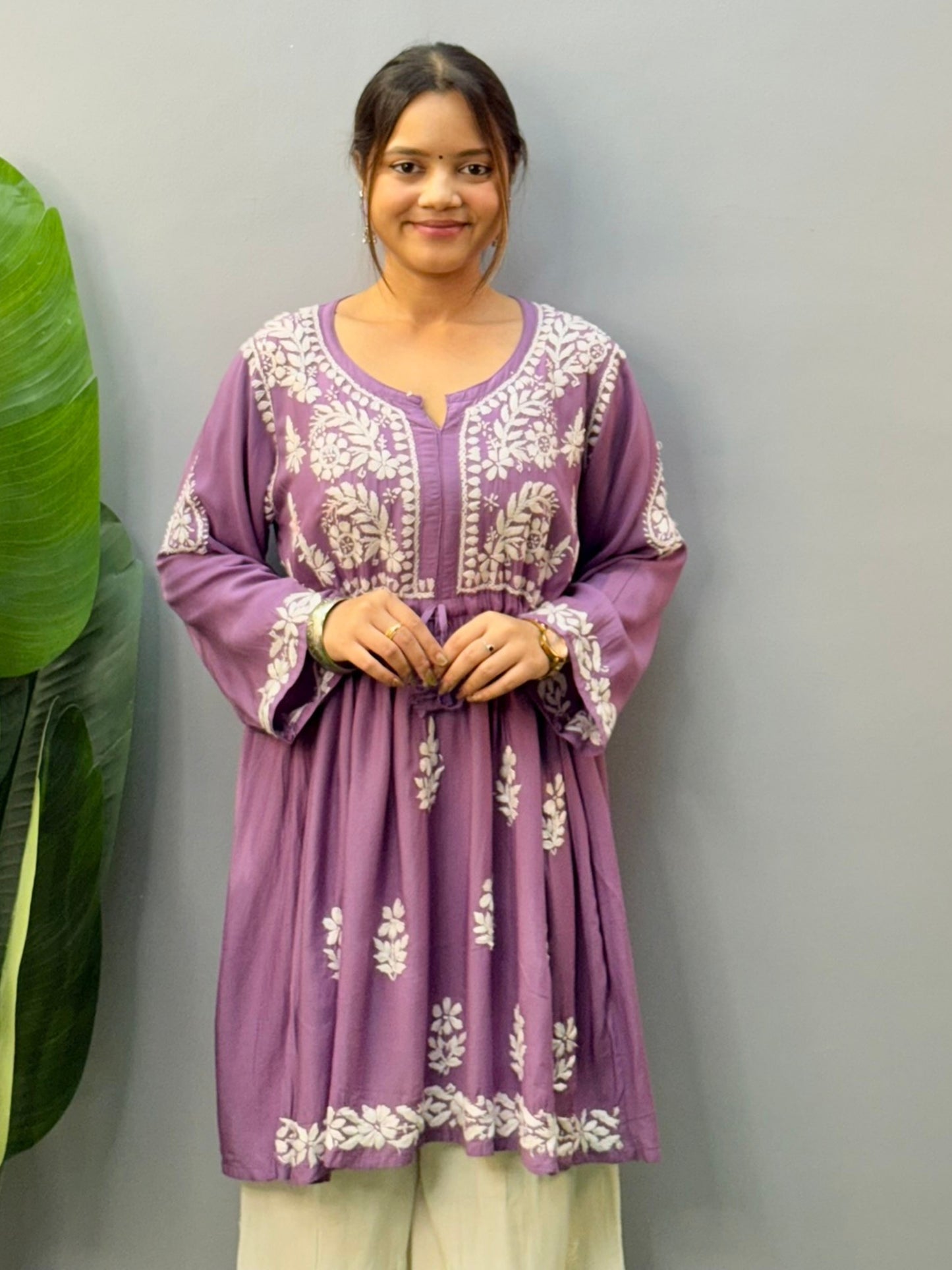 Woman wearing lavender flair short kurta with white Chikankari embroidery on modal fabric