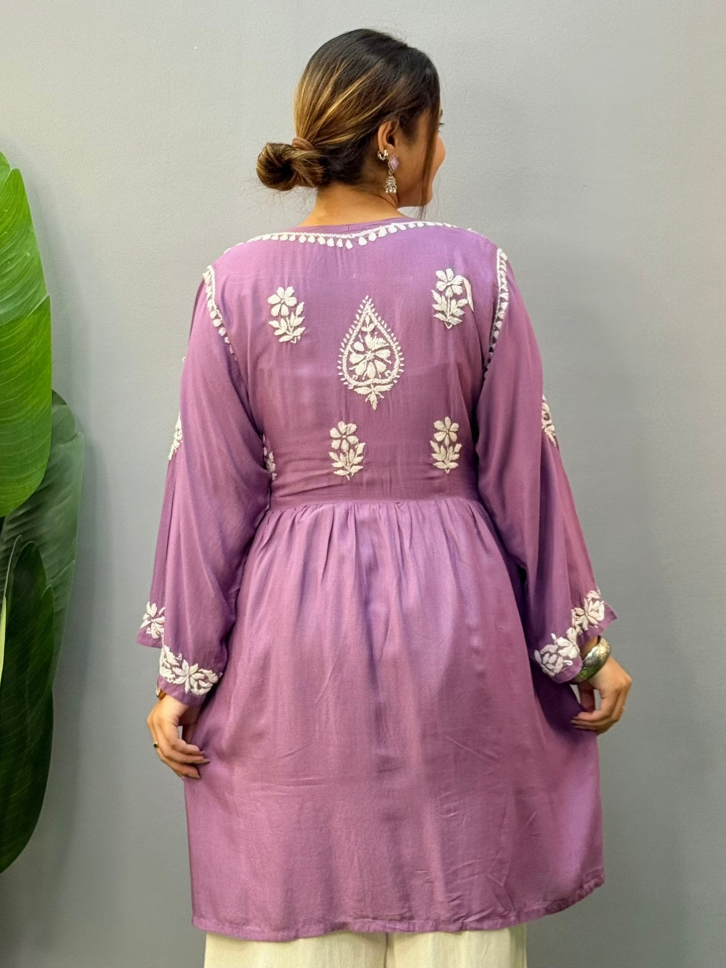Woman wearing lavender flair short kurta with white Chikankari embroidery on modal fabric