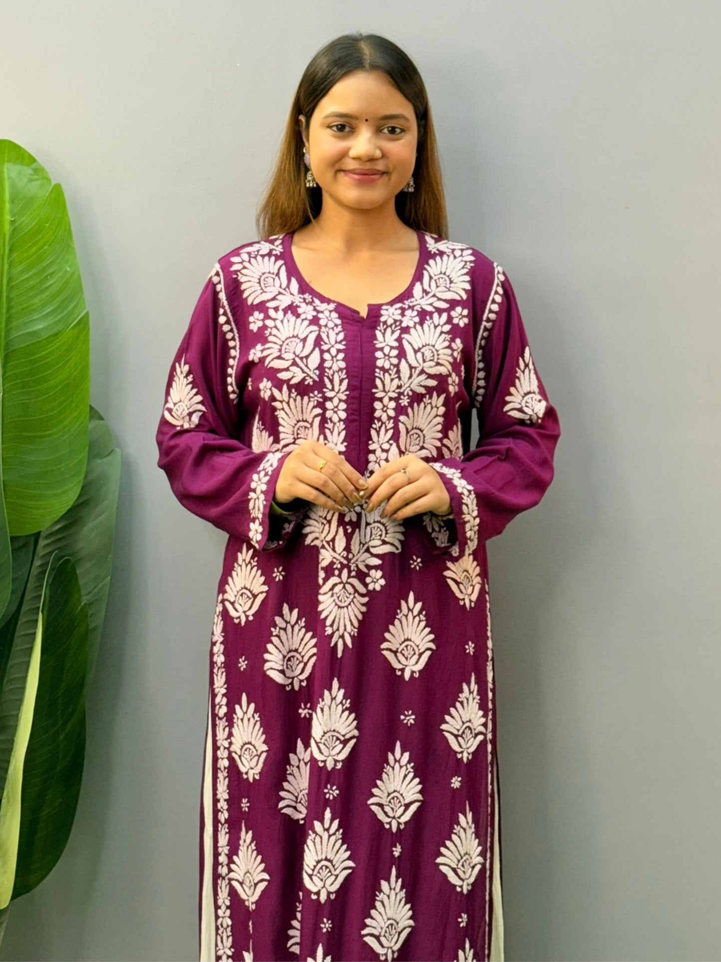 Woman wearing a plum purple modal chikankari kurta with white embroidery and off-white palazzos
