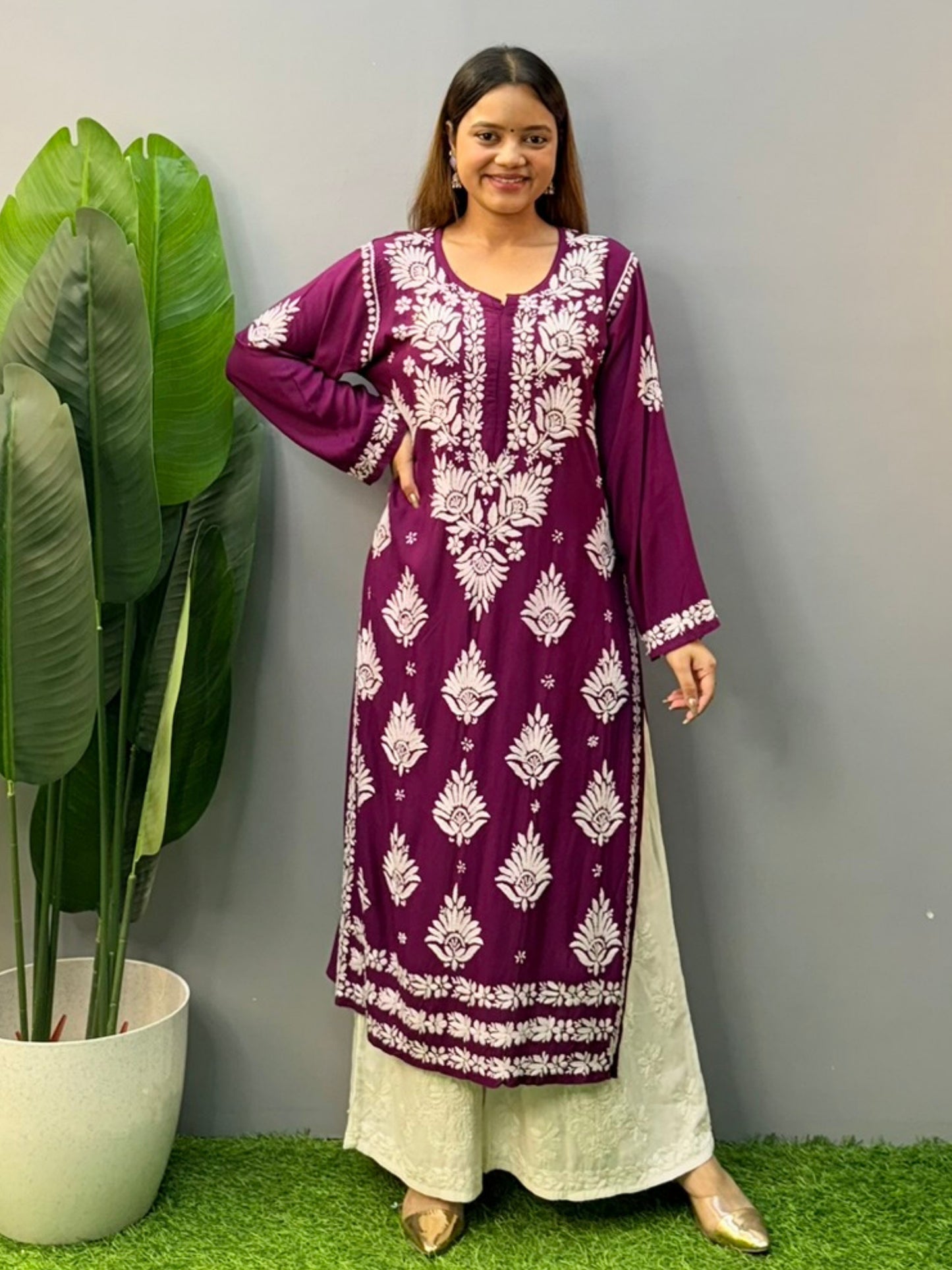 Woman wearing a plum purple modal chikankari kurta with white embroidery and off-white palazzos