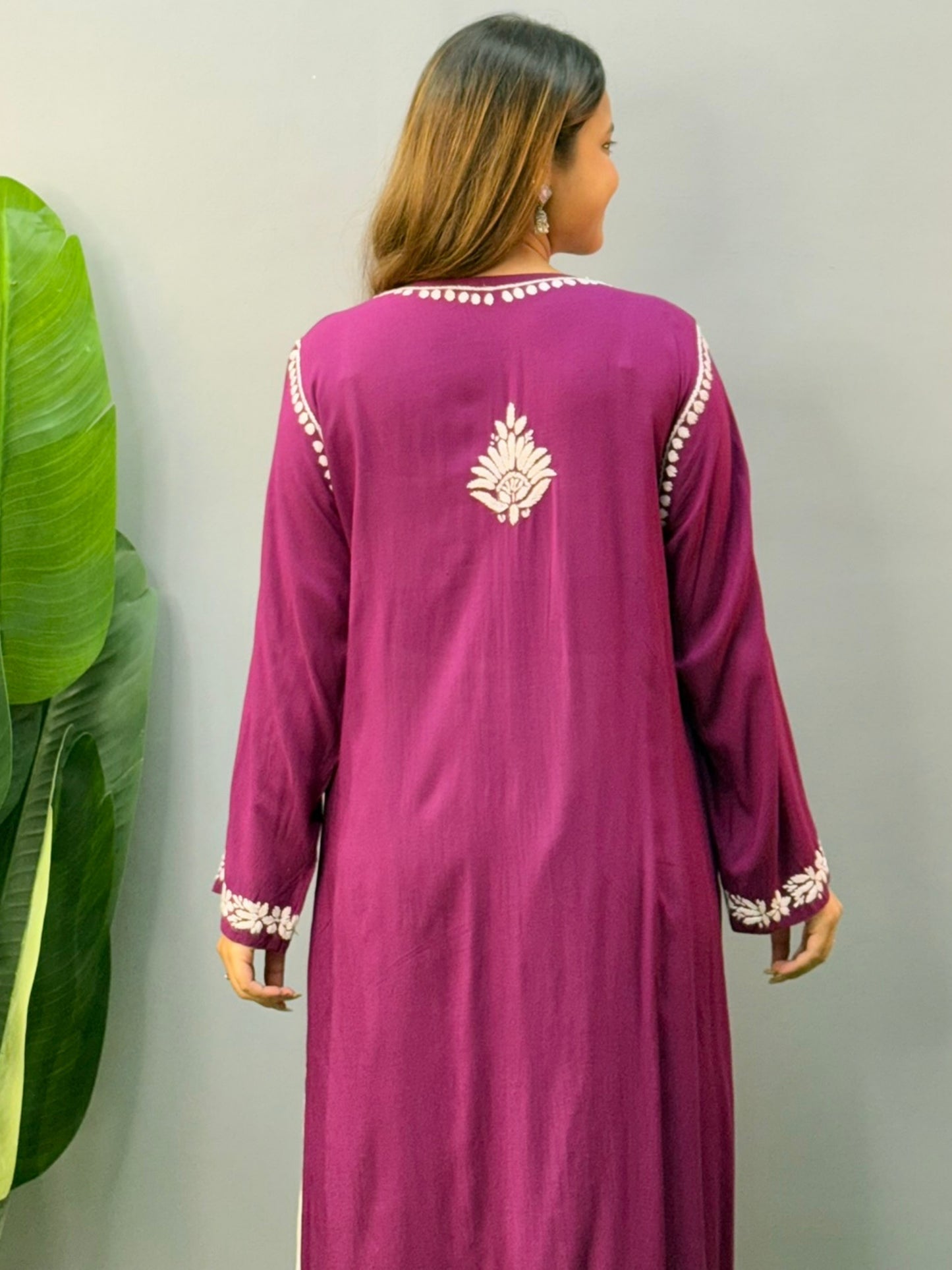 Woman wearing a plum purple modal chikankari kurta with white embroidery and off-white palazzos