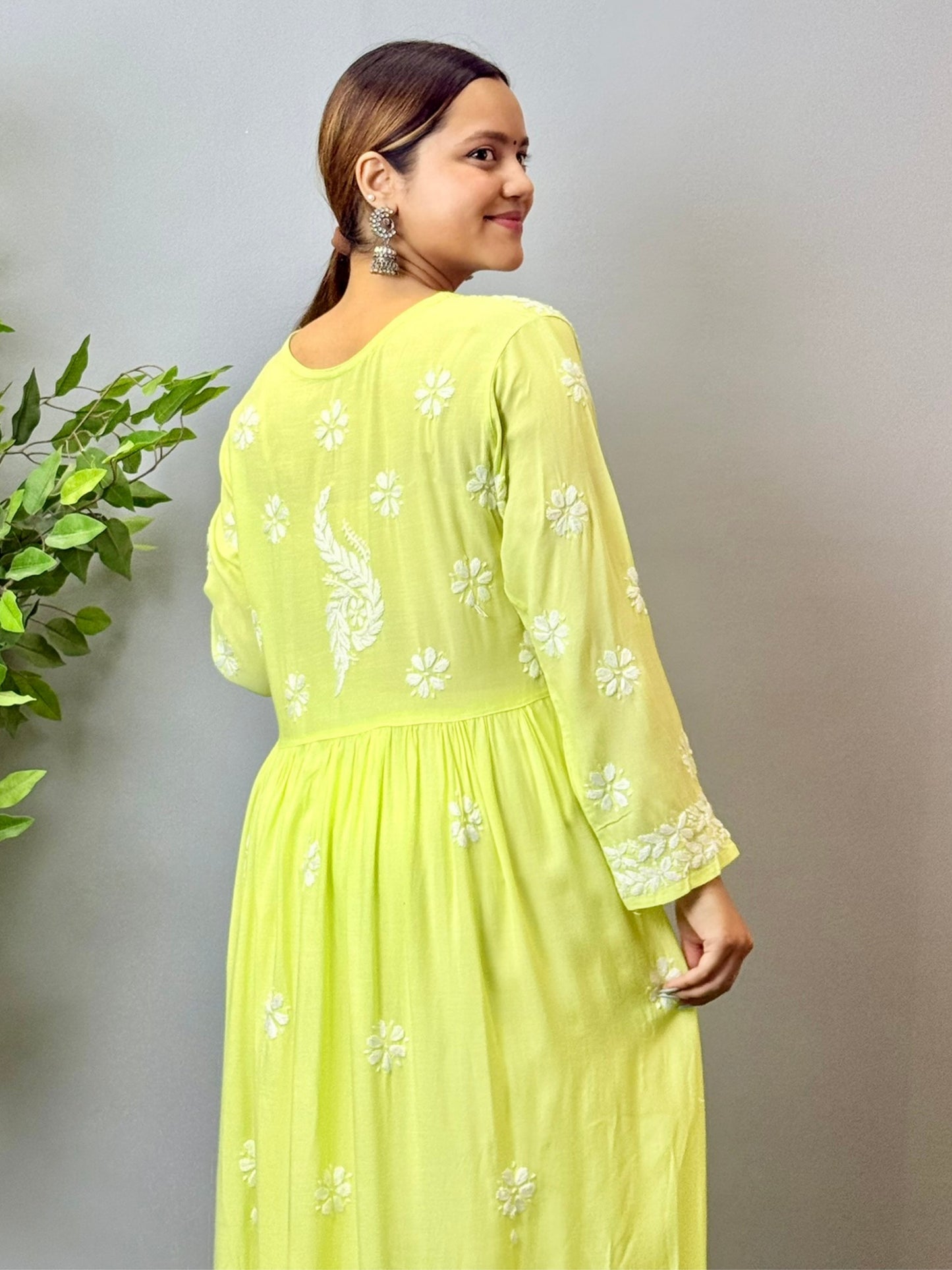 Model wearing a lime green Lucknowi chikankari long frock in modal fabric with delicate white hand embroidery and flared silhouette.