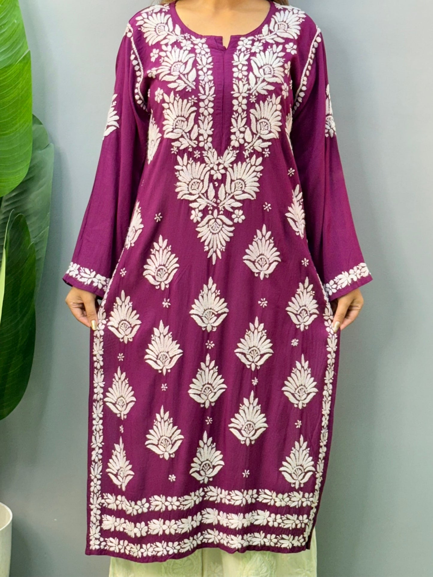 Woman wearing a plum purple modal chikankari kurta with white embroidery and off-white palazzos