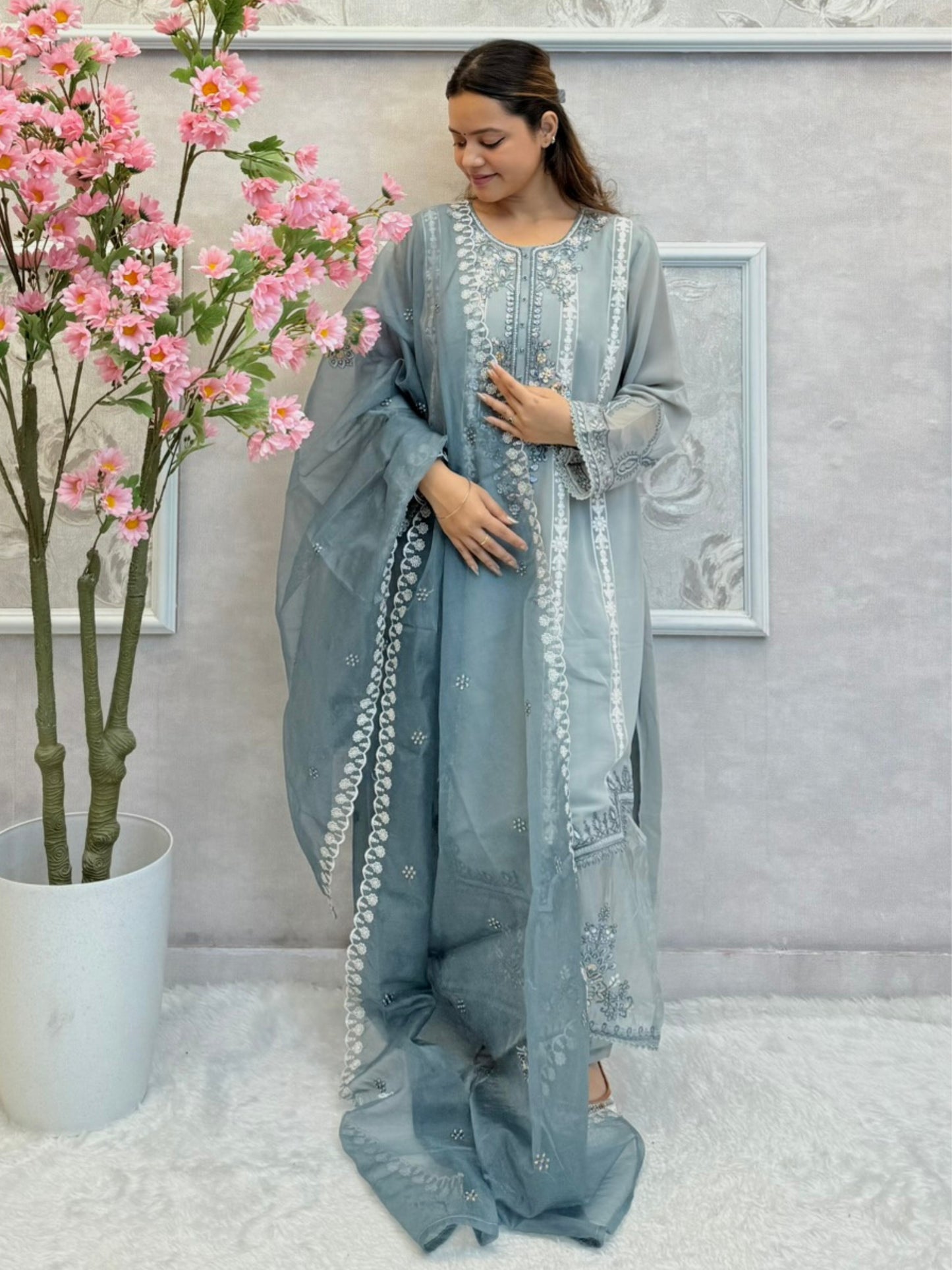 Model wearing dusty blue chikankari designer suit with organza dupatta