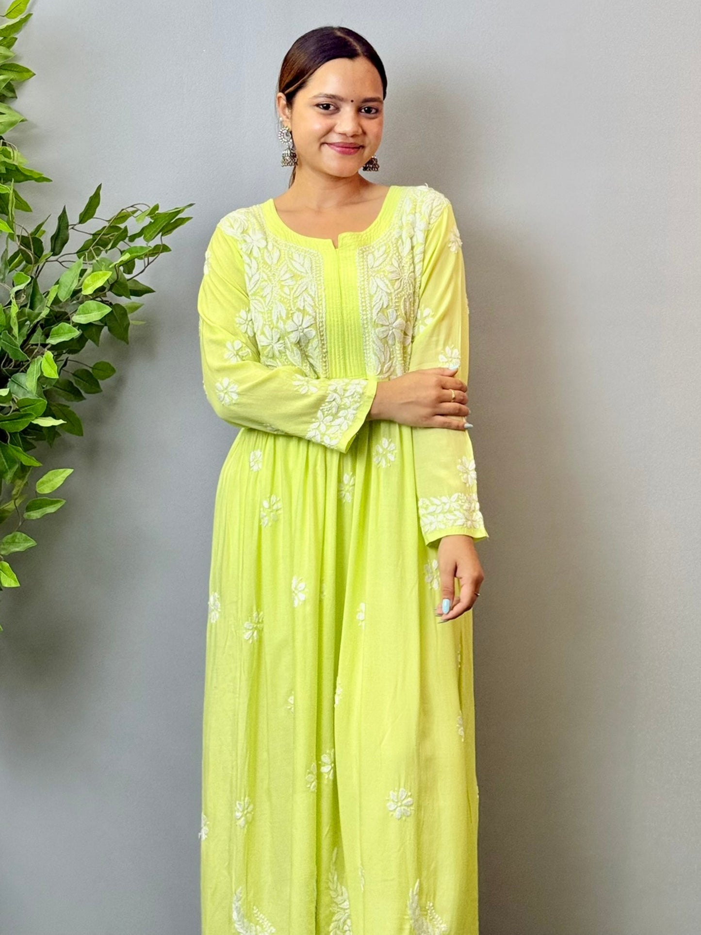 Model wearing a lime green Lucknowi chikankari long frock in modal fabric with delicate white hand embroidery and flared silhouette.
