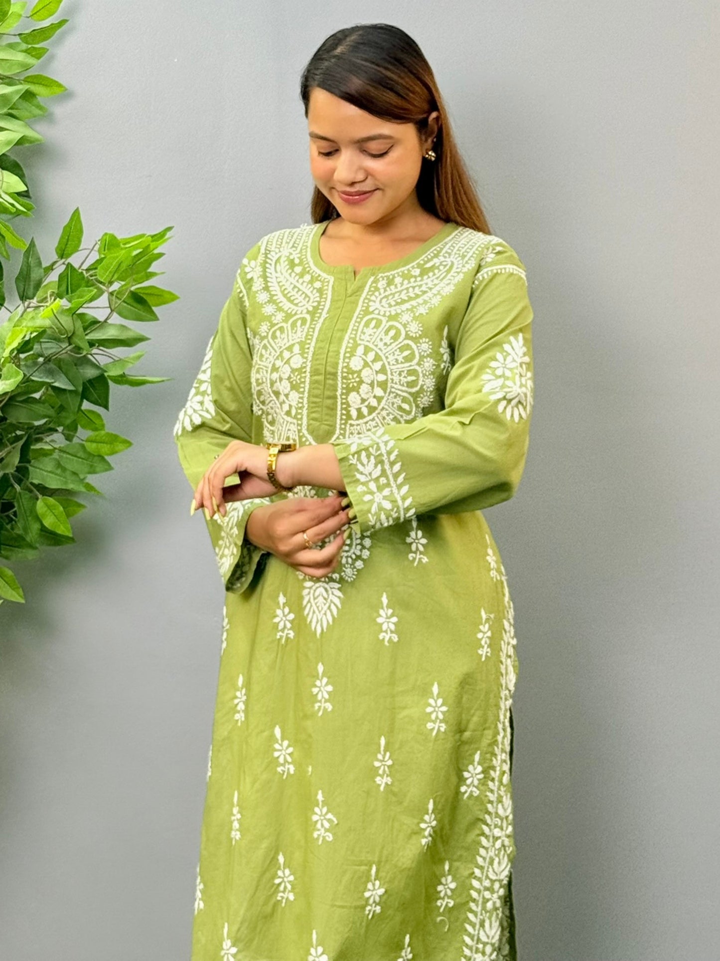 Model wearing an olive green cotton chikankari kurta with intricate white embroidery