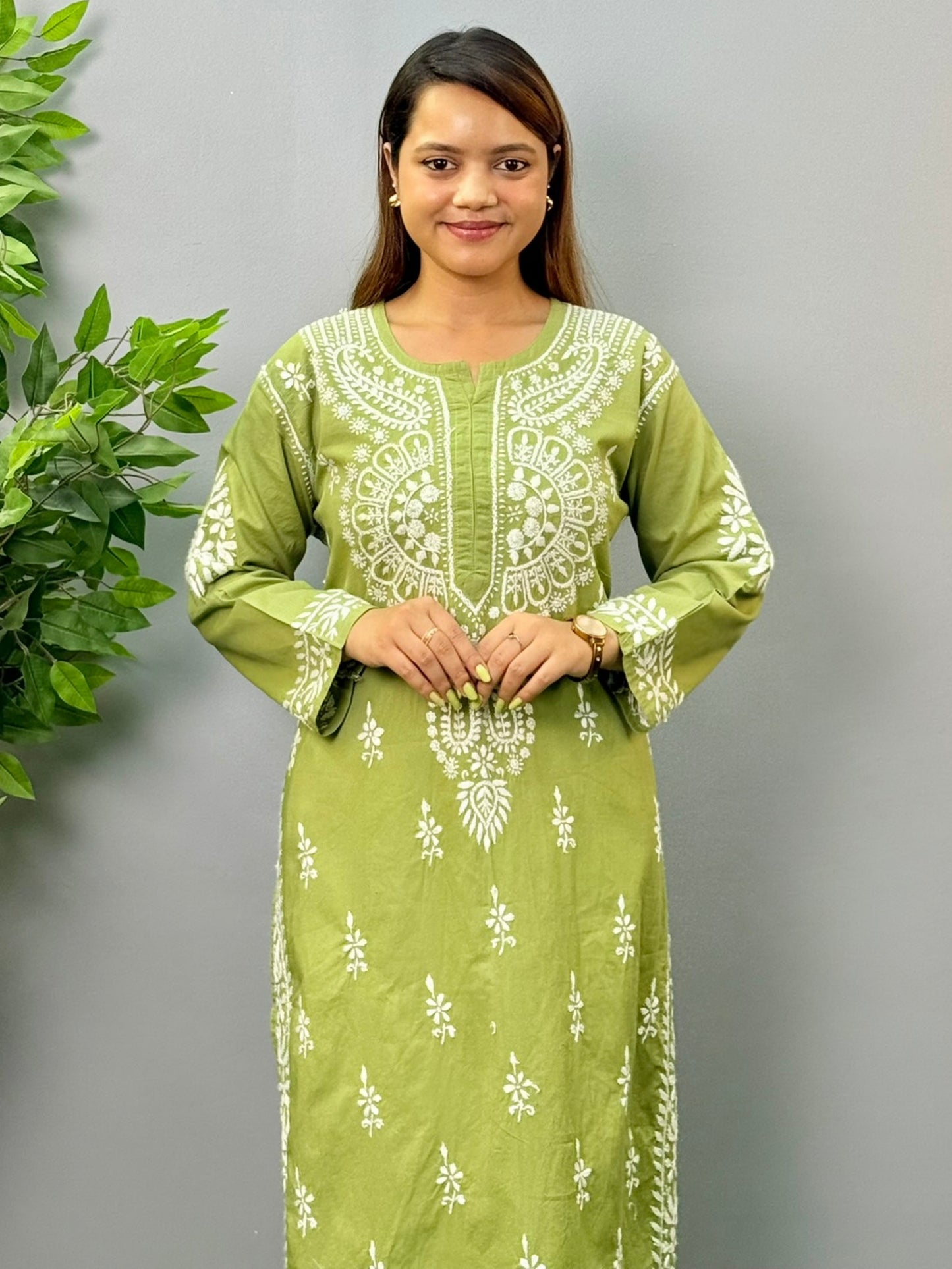 Model wearing an olive green cotton chikankari kurta with intricate white embroidery