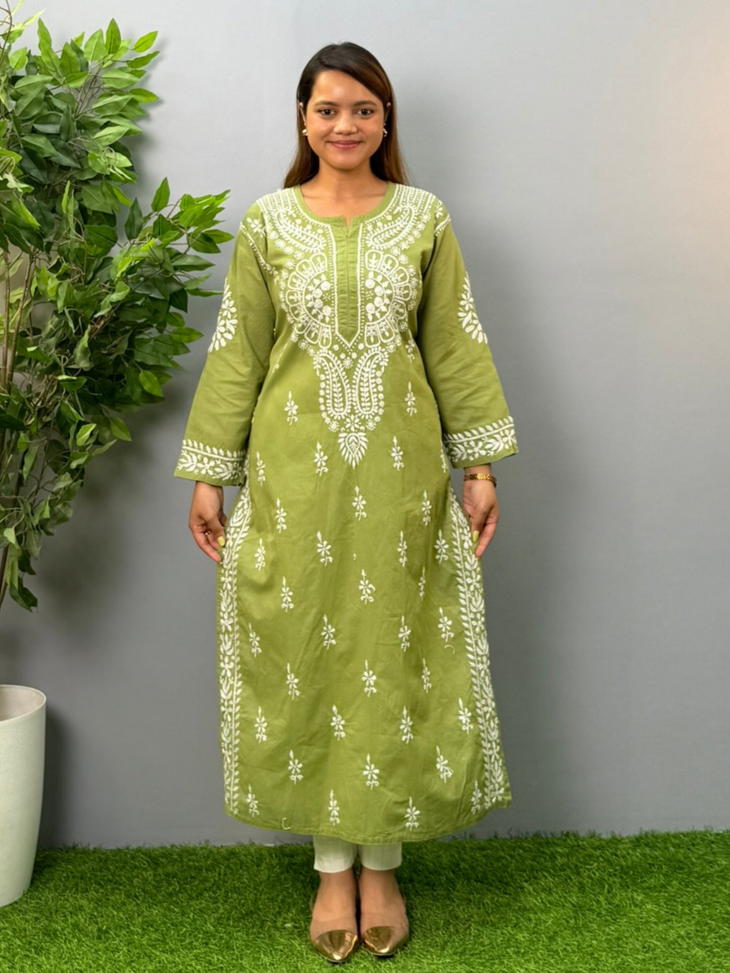 Model wearing an olive green cotton chikankari kurta with intricate white embroidery