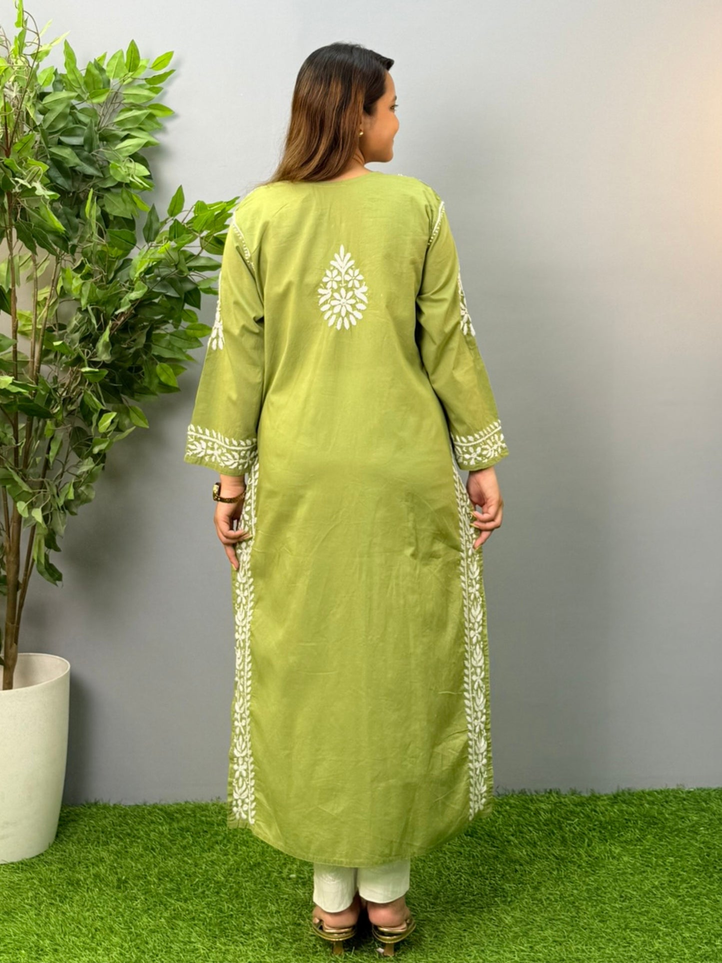 Model wearing an olive green cotton chikankari kurta with intricate white embroidery