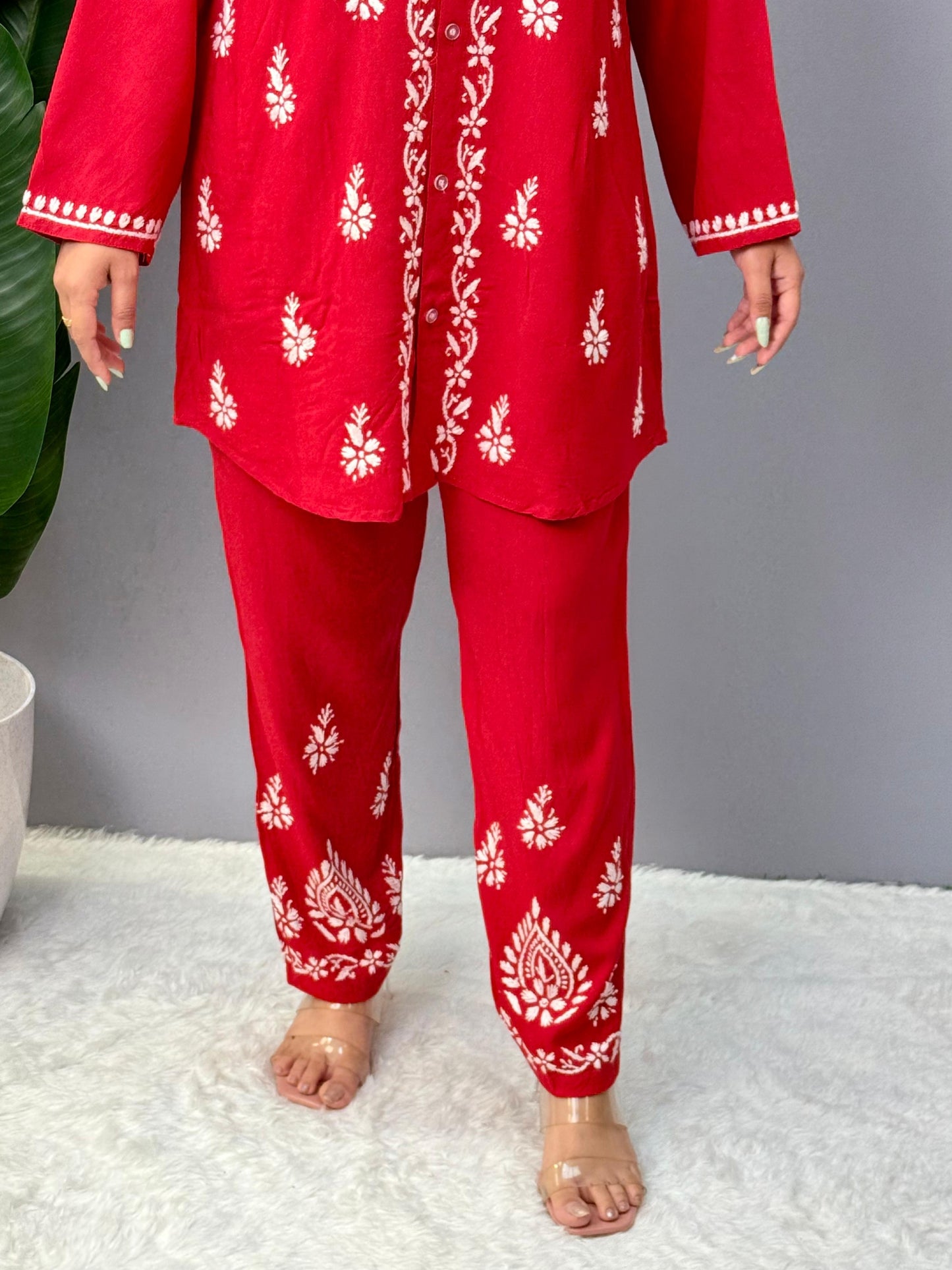 Model wearing a red rayon Lucknowi chikankari co-ord set featuring white hand embroidery on shirt-style kurta and matching pants.